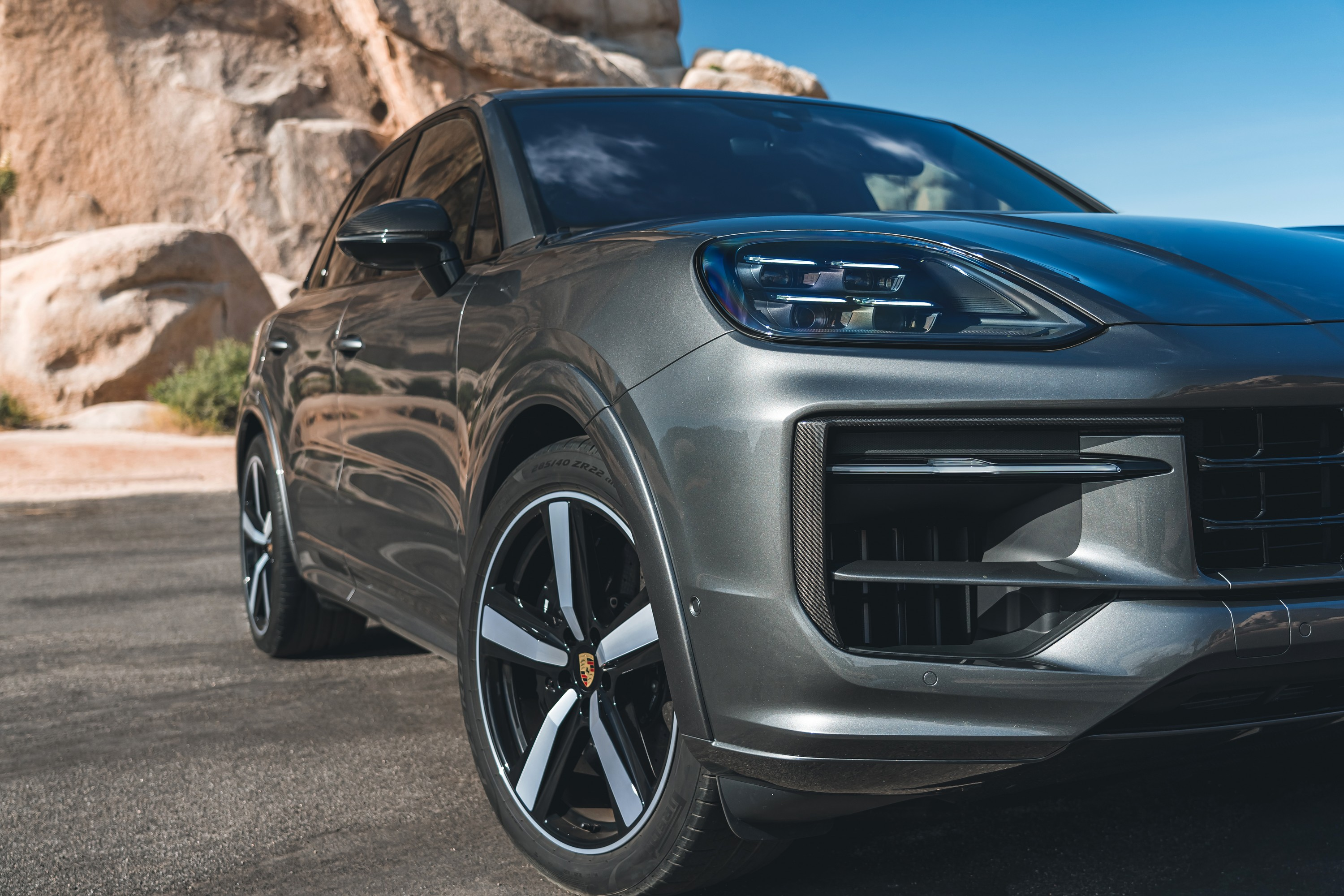 Front-three-quarter close-up of the 2024 Porsche Cayenne SUV. It's gray.