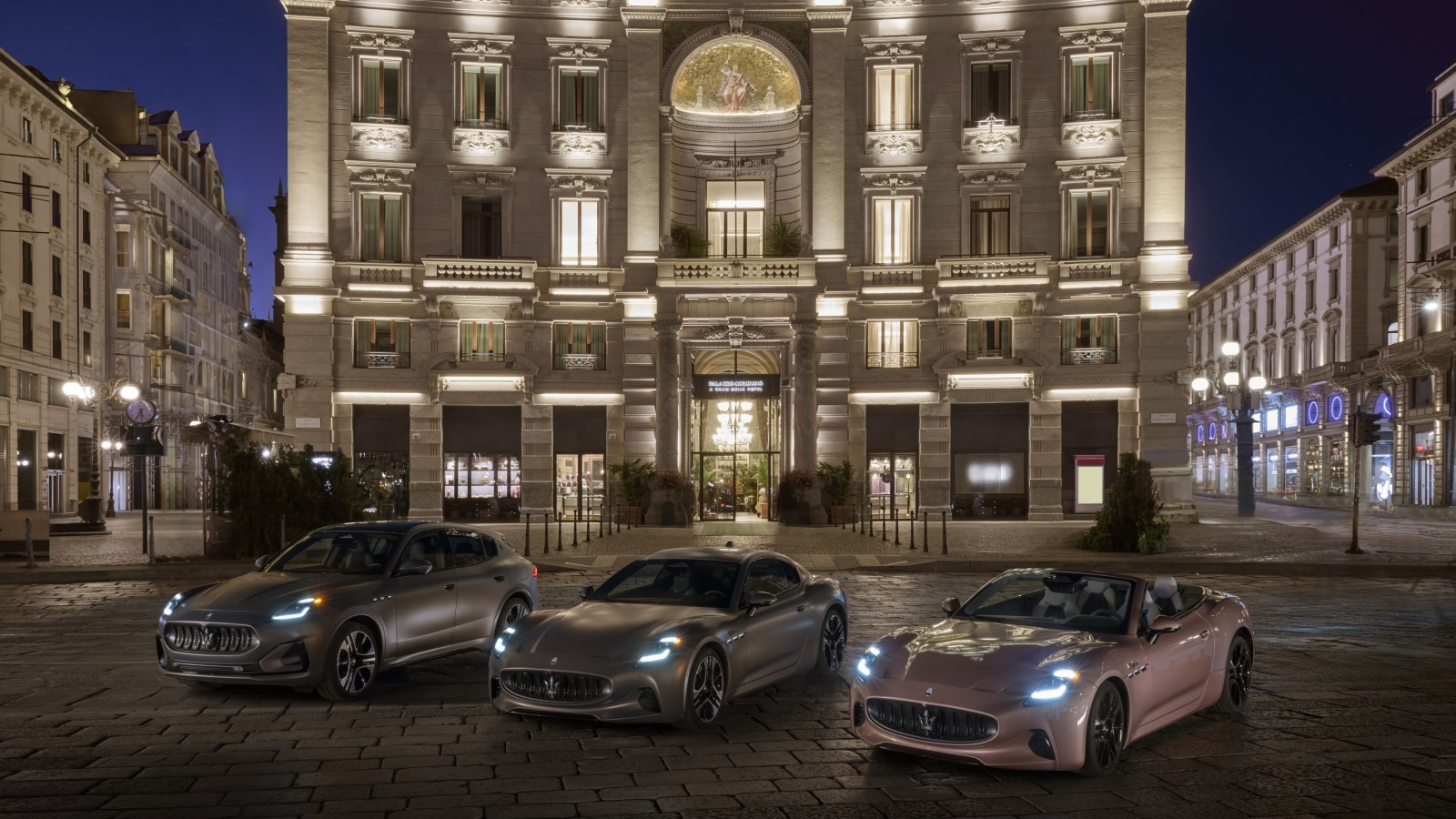 A photo of three electric Maserati cars parked in front of a historic building. 