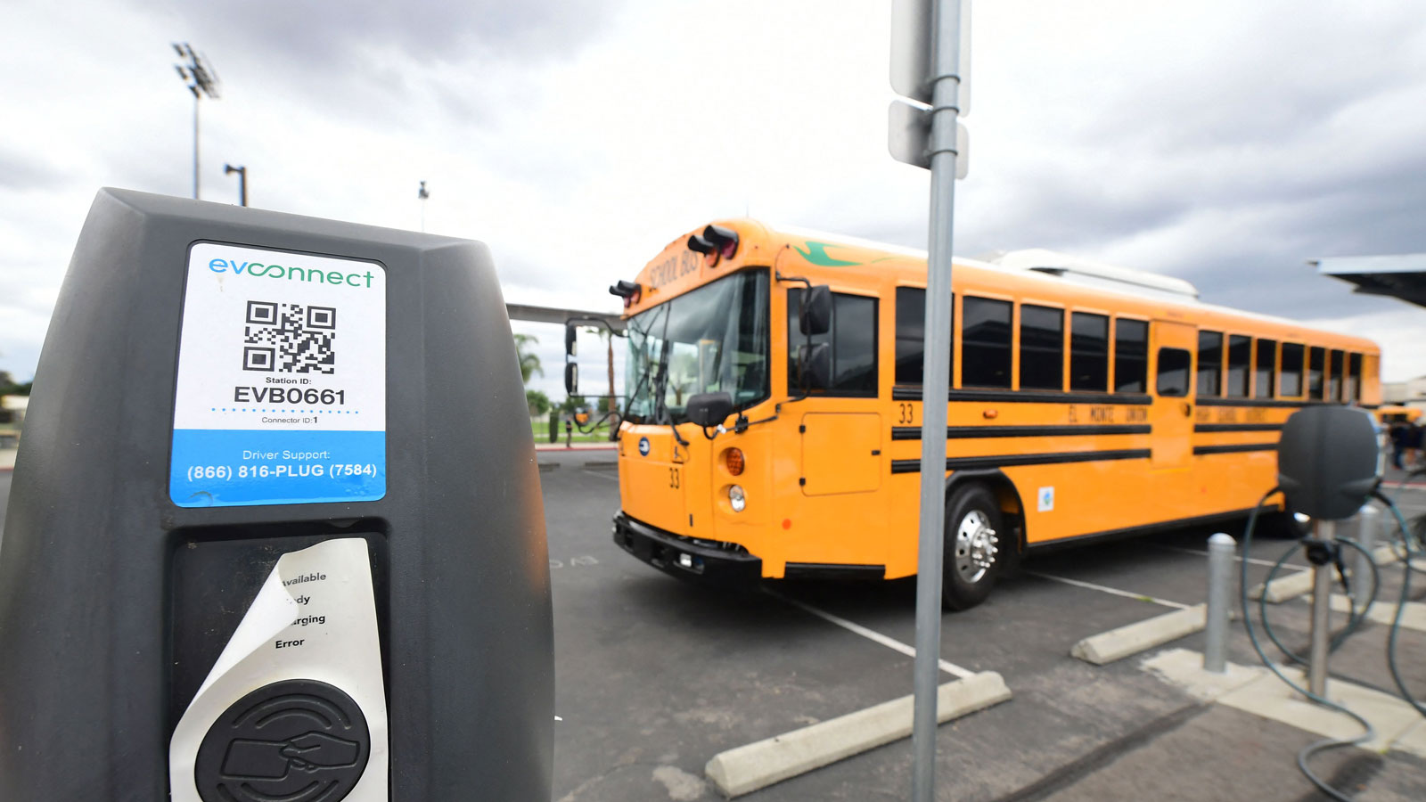 A photo of an electric school bus charging at a station. 