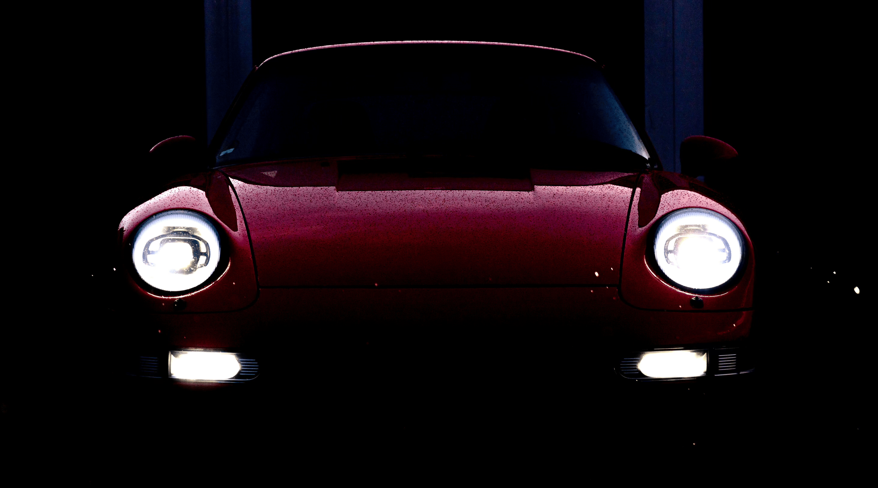 A photo of a wet red 993 with Ruf LED headlights 