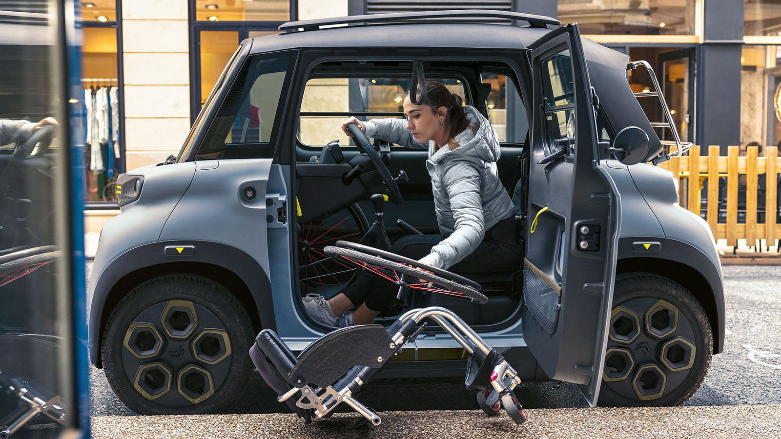 A photo of a person in the driving seat of the Citroen Ami. 