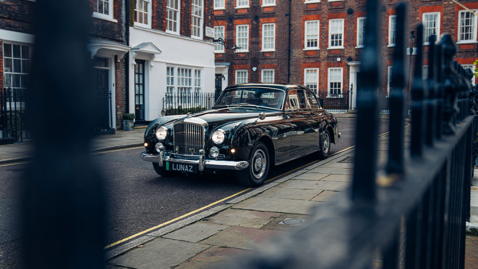 A photo of the Bentley EV taken through a railing. 