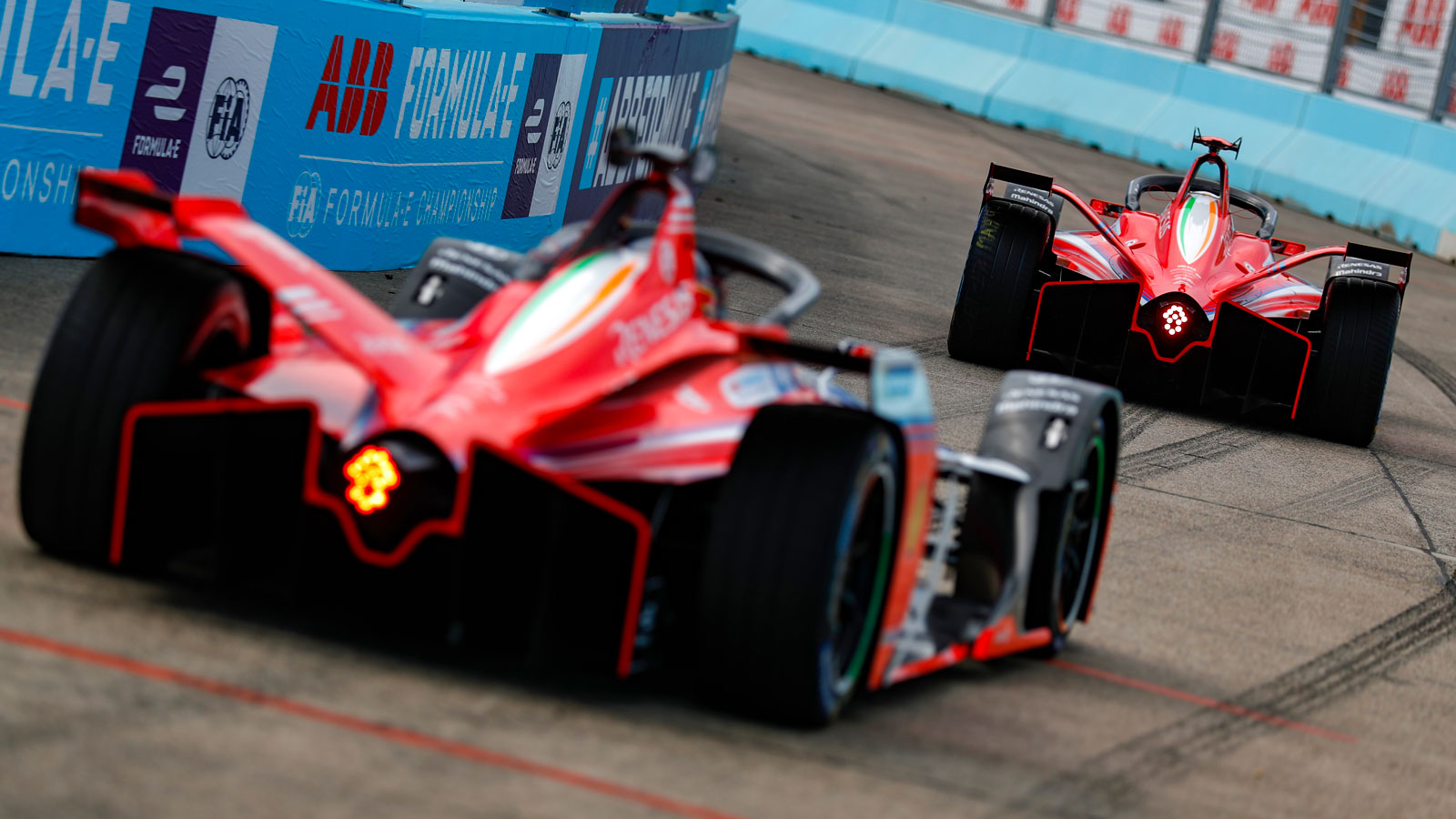 Two Formula E cars head to the grid. 