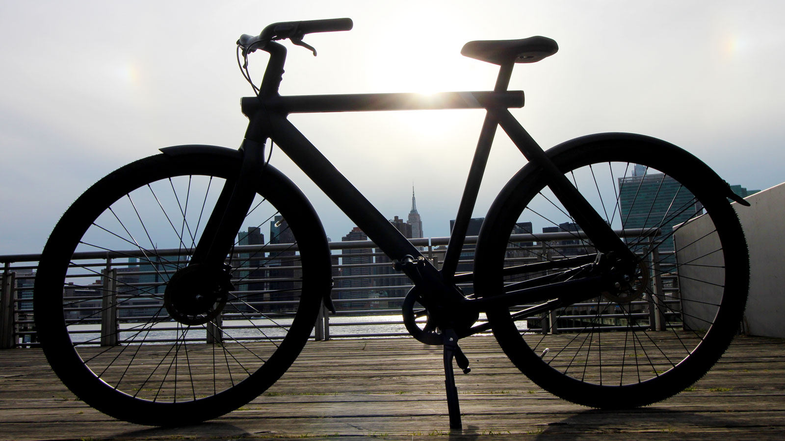 A photo of a VanMoof electric bike with the Empire State Building in the background. 