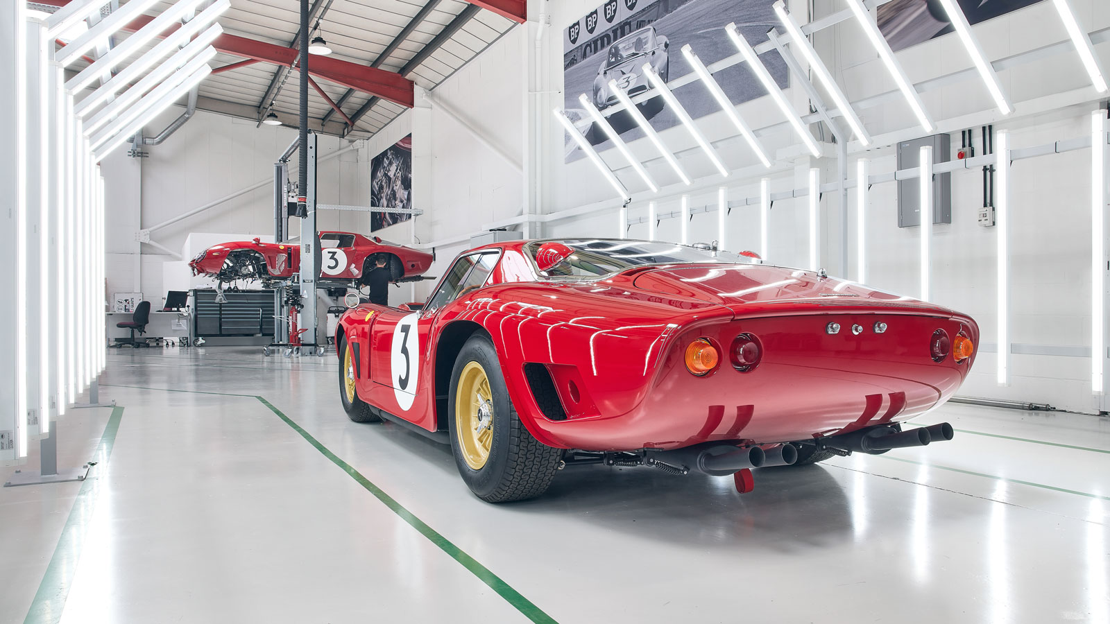 A photo of the rear quarter of the Revival cars parked in a factory. 