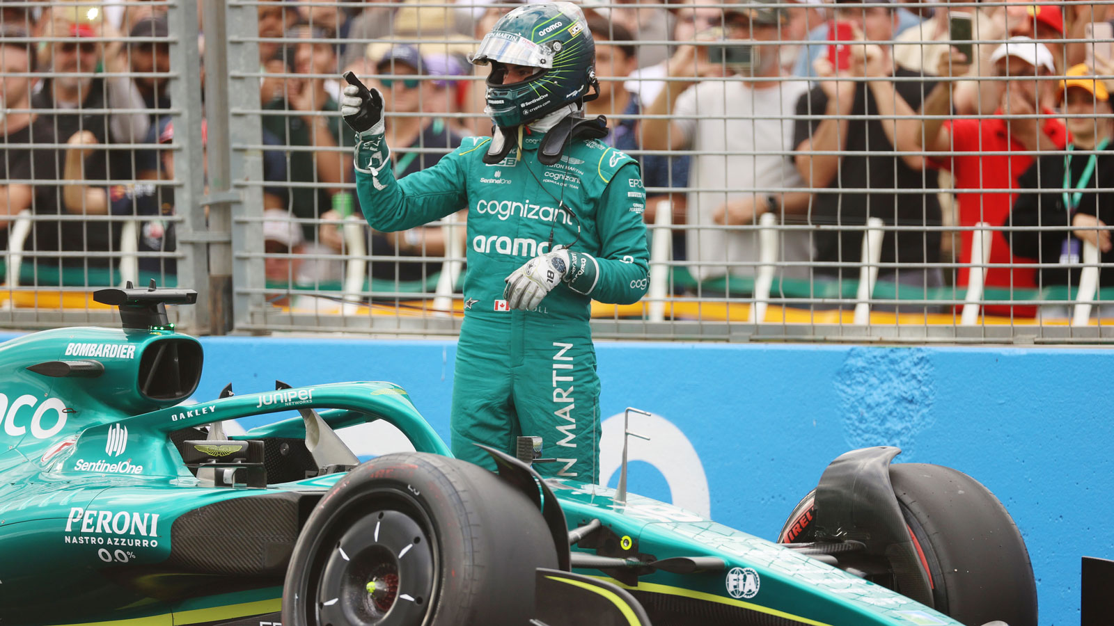 A photo of Lance Stroll and his crashed Aston Martin F1 car. 