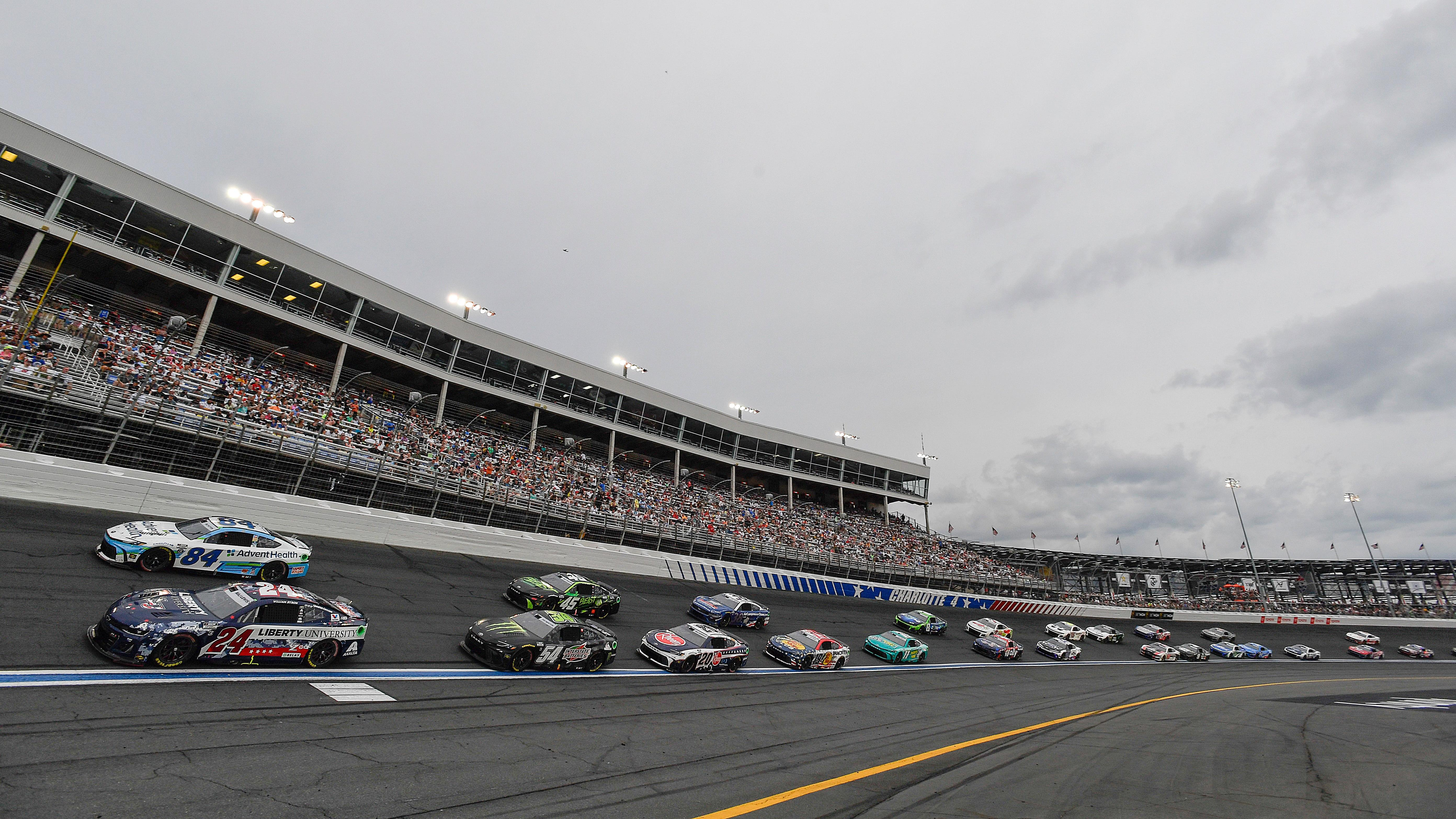 William Byron, driver of the #24 Liberty University Patriotic Chevrolet, and Jimmie Johnson, driver of the #84 AdventHealth Toyota, race during the NASCAR Cup Series Coca-Cola 600 at Charlotte Motor Speedway on May 26, 2024 in Concord, North Carolina.