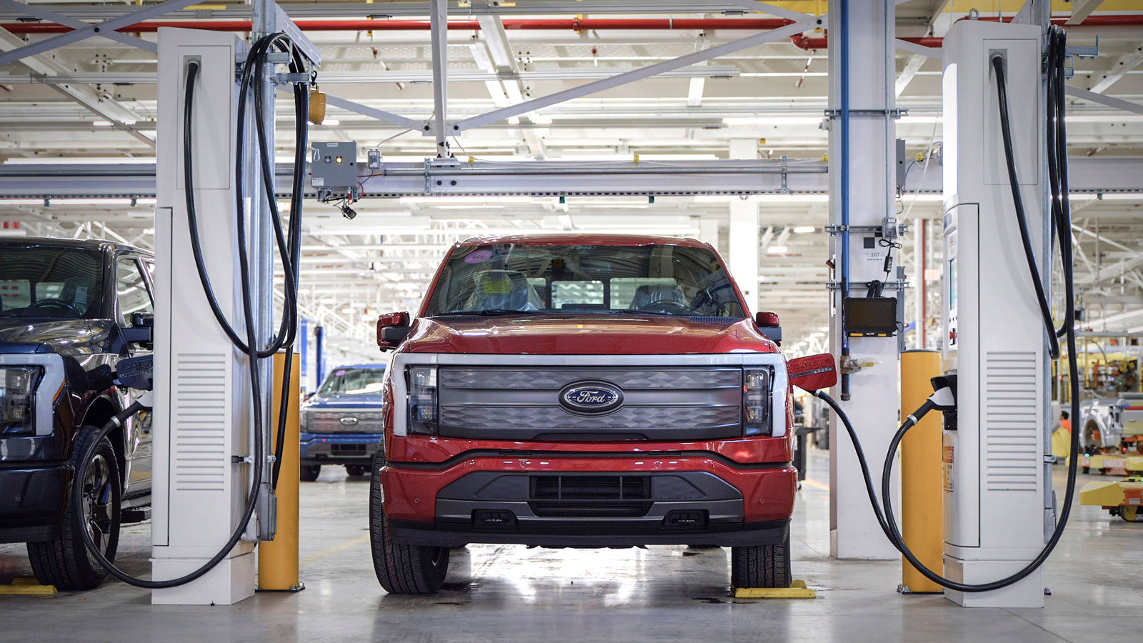 A photo of a Ford F-150 Lightning truck charging at a factory. 