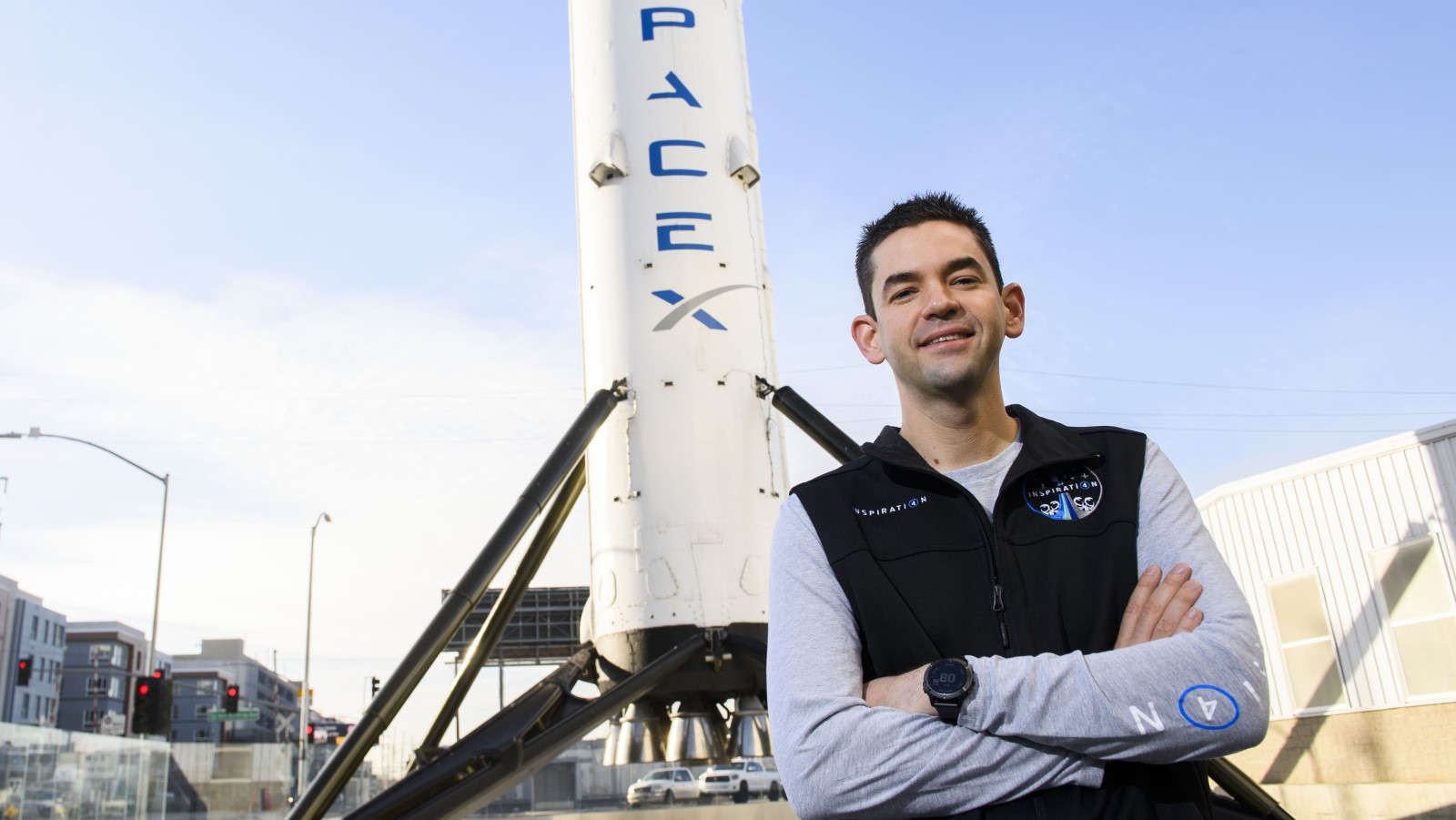 A photo of billionaire Jared Isaacman in front of a SpaceX rocket.