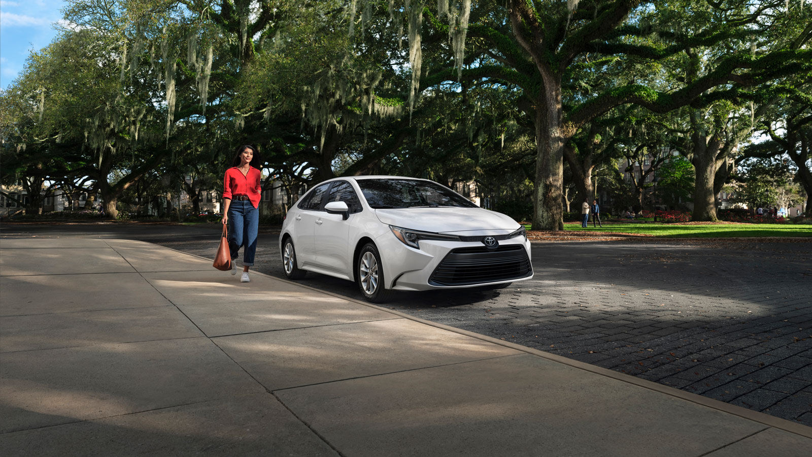 A photo of a white Toyota Corolla sedan parked on a street. 