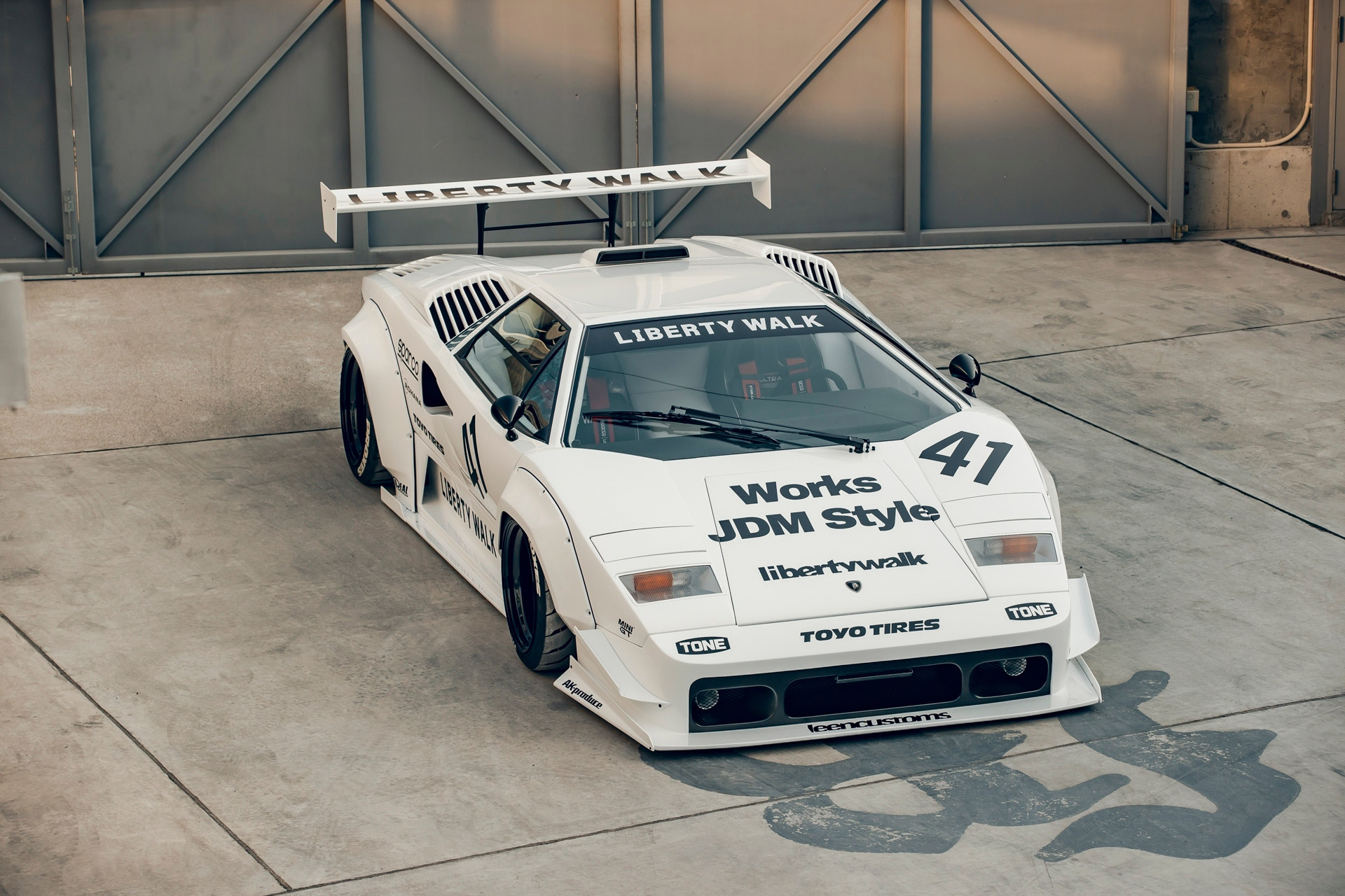 Front 3/4 view of a white Lamborghini Countach with a Liberty Walk body kit