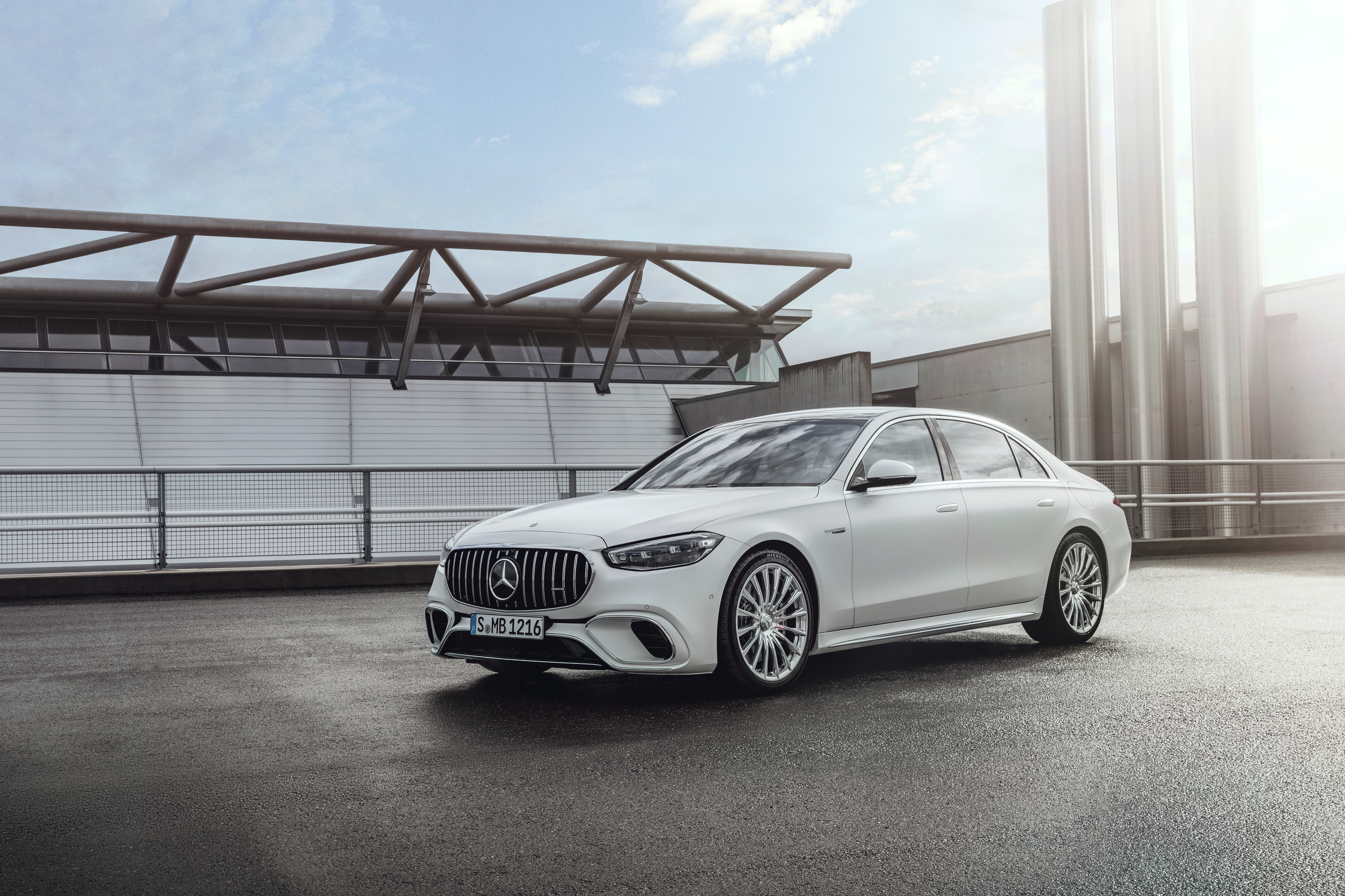 a white 2023 mercedes-amg s 63 e performance sedan seen from the front left, parked on the roof of a parking garage