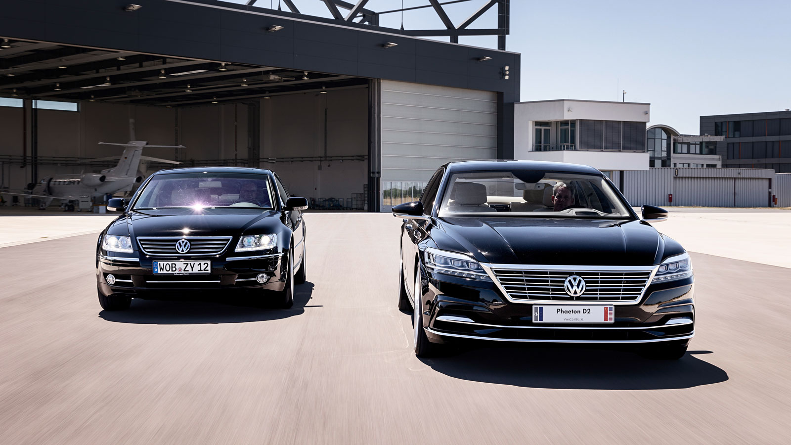 A photo of the original VW Phaeton driving alongside the Phaeton D2 concept car. 