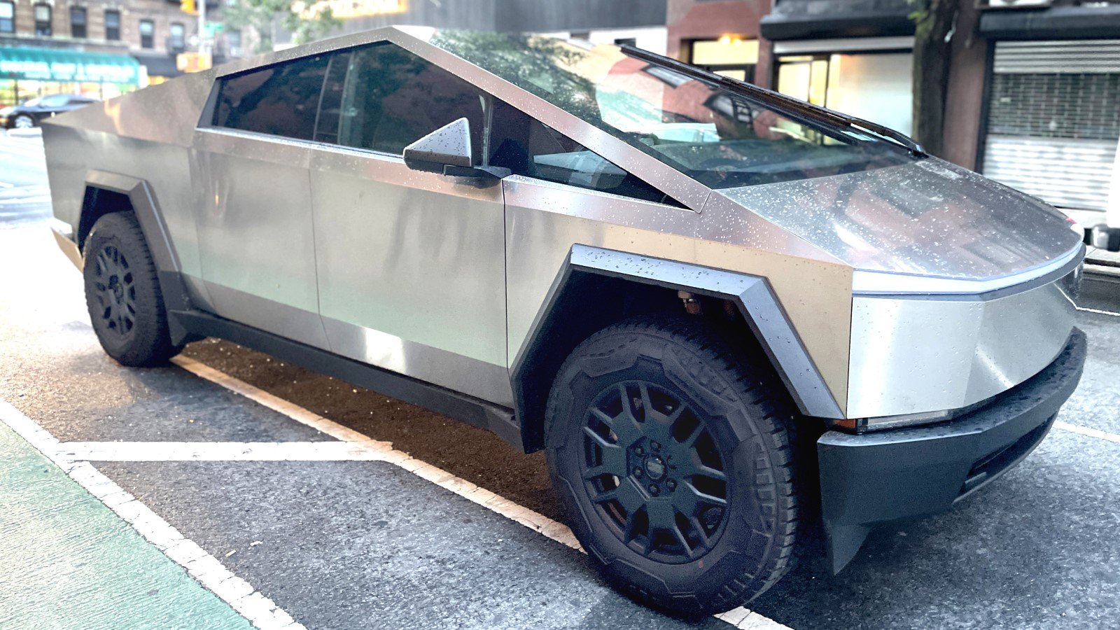 A photo of a Tesla Cybertruck parked by the side of the road. 