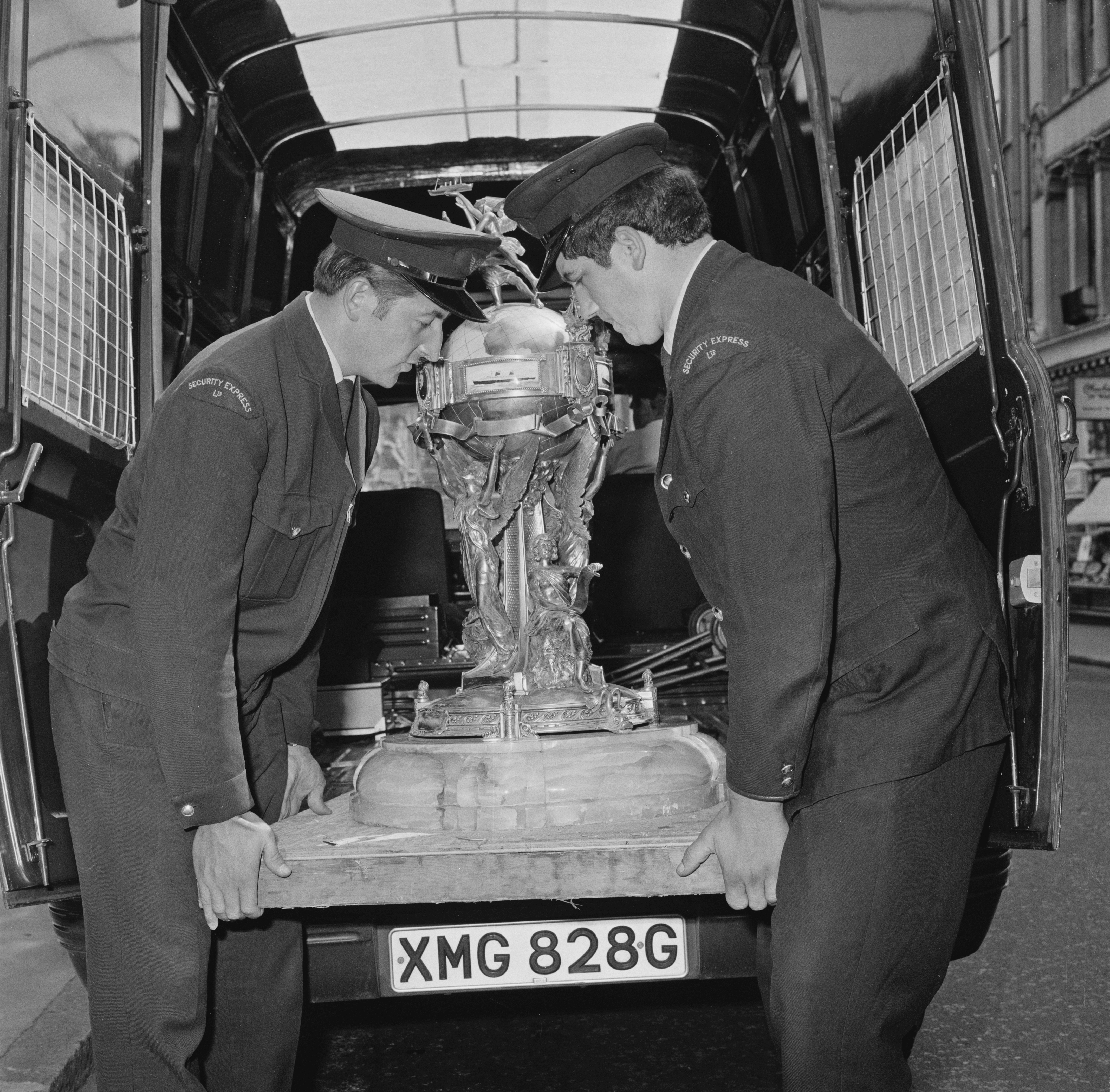 Two officers carrying the Hales Trophy, award for the fastest Atlantic crossing by a commercial vessel, UK, 6th August 1969.