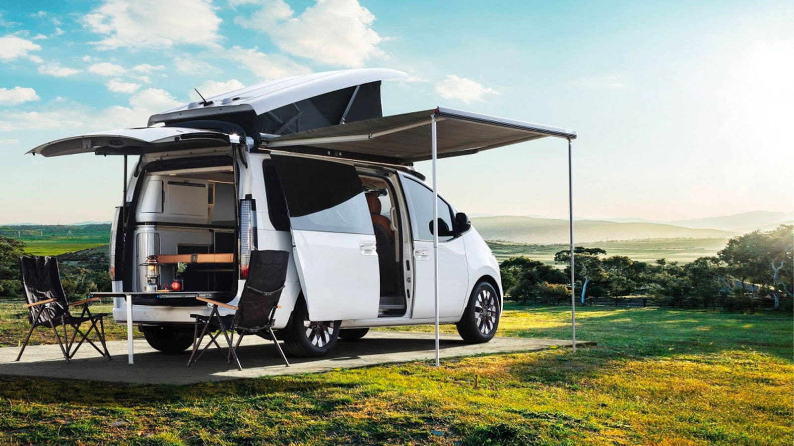 A photo of the Hyundai Staria Lounge camper with its door and trunk open. 