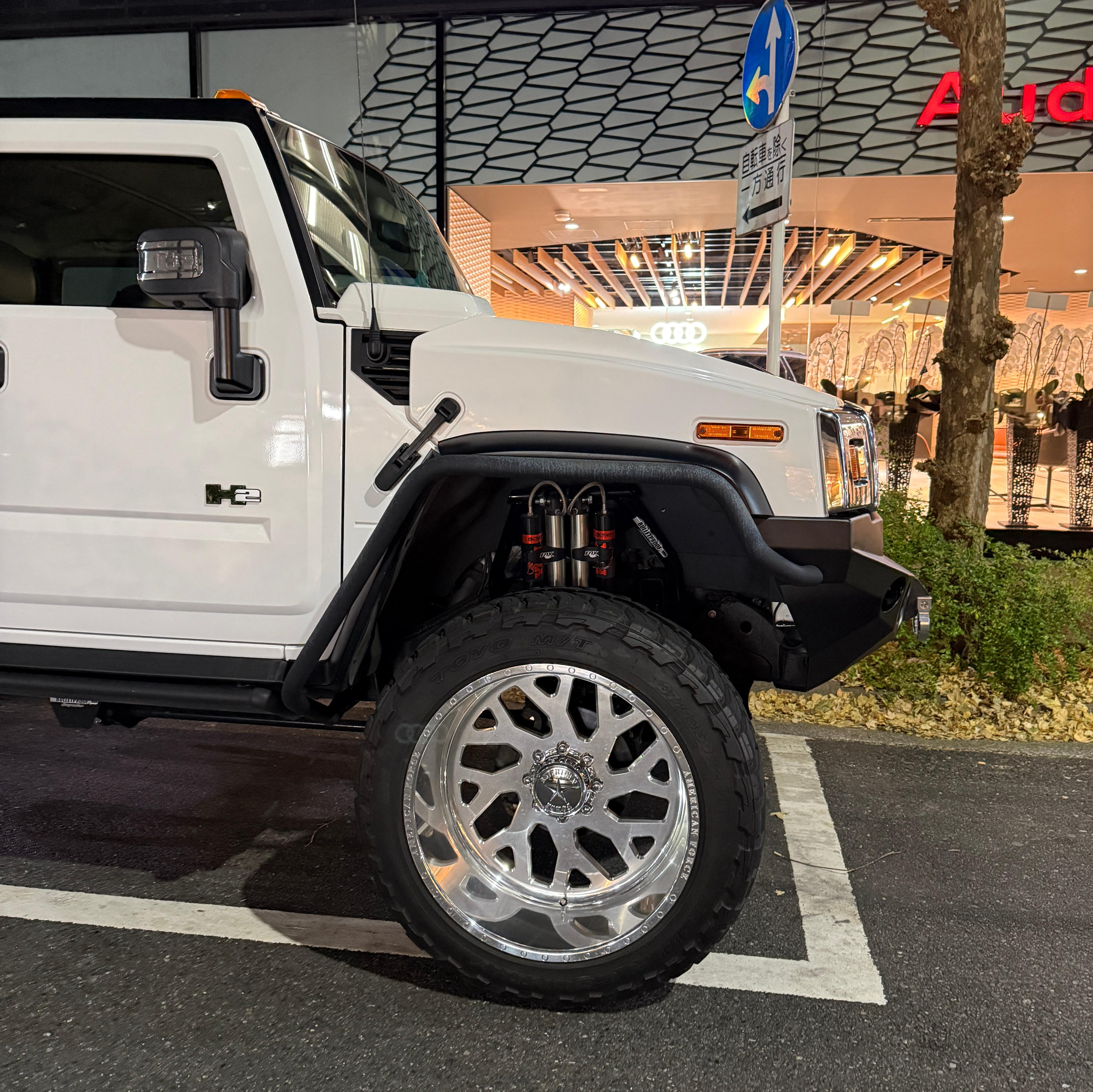 Front wheel of a lifted white Hummer H2