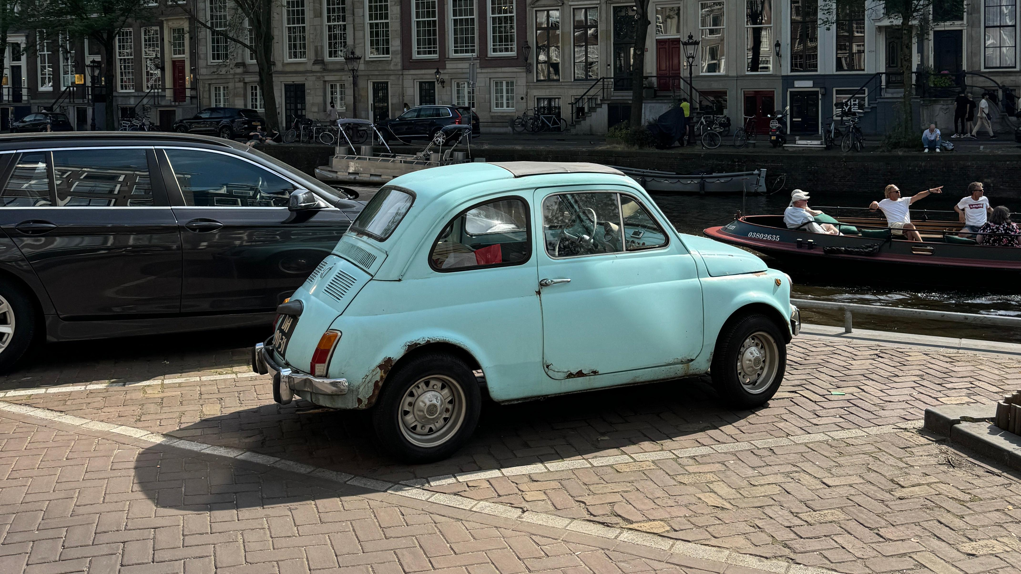 Rear 3/4 view of a vintage blue Fiat 500