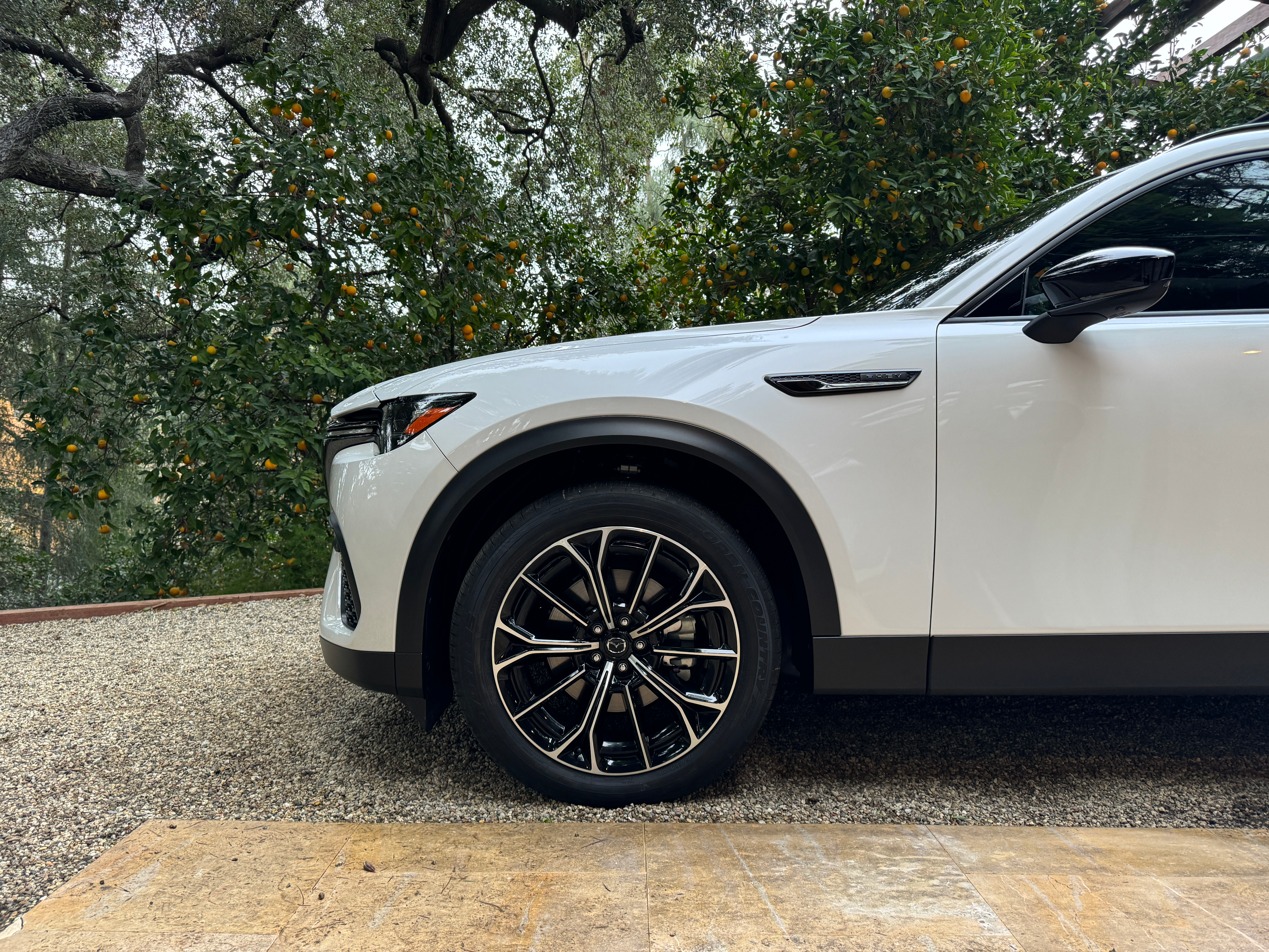 The wheels and front fender of a white 2025 Mazda CX-70