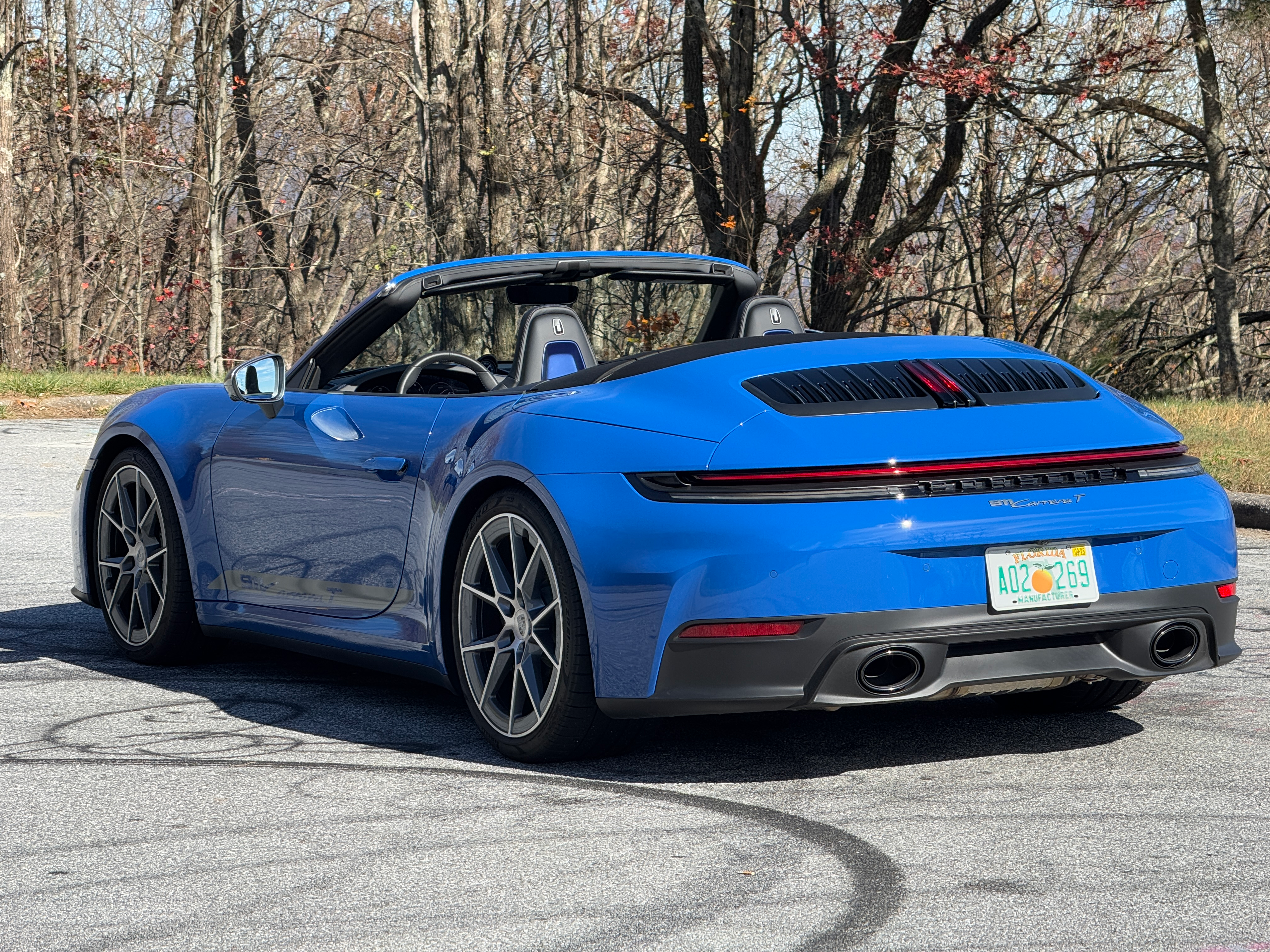 Rear 3/4 view of a blue 2025 Porsche 911 Carrera T cabriolet