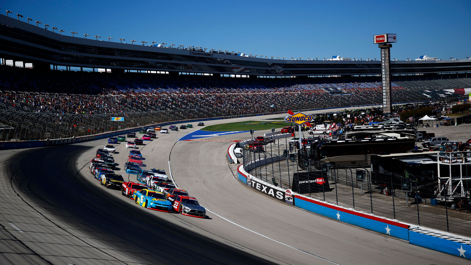 Nascar racers drive around an oval circuit 