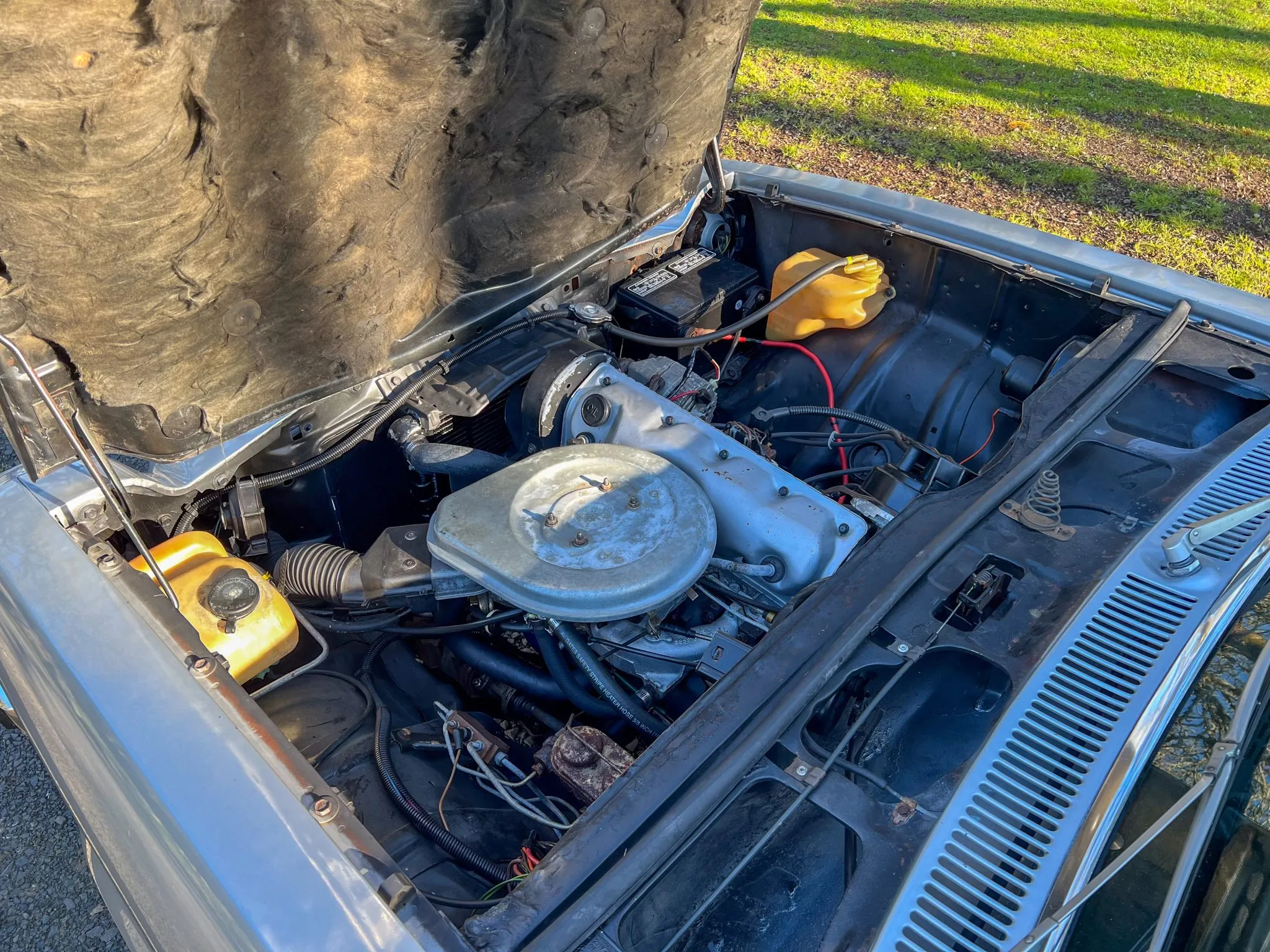 A look under the front-hinged hood at the tiny four cylinder engine