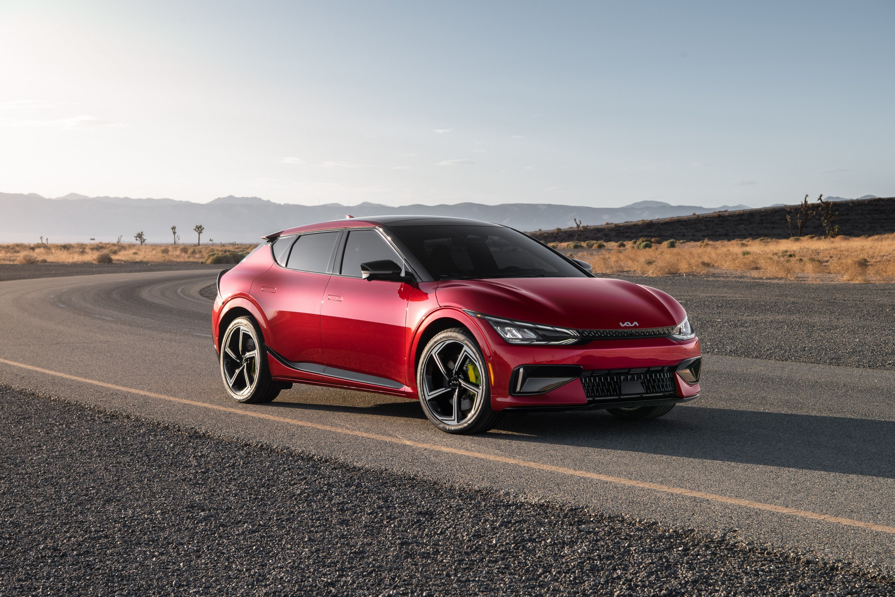 A red 2023 Kia EV6 GT is parked on a desert road.