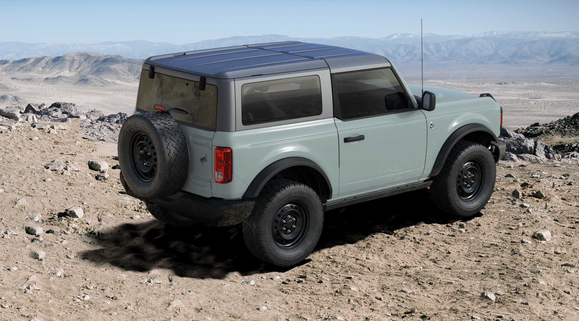 A 2023 Ford Bronco two-door in cactus gray is parked on a mountain.