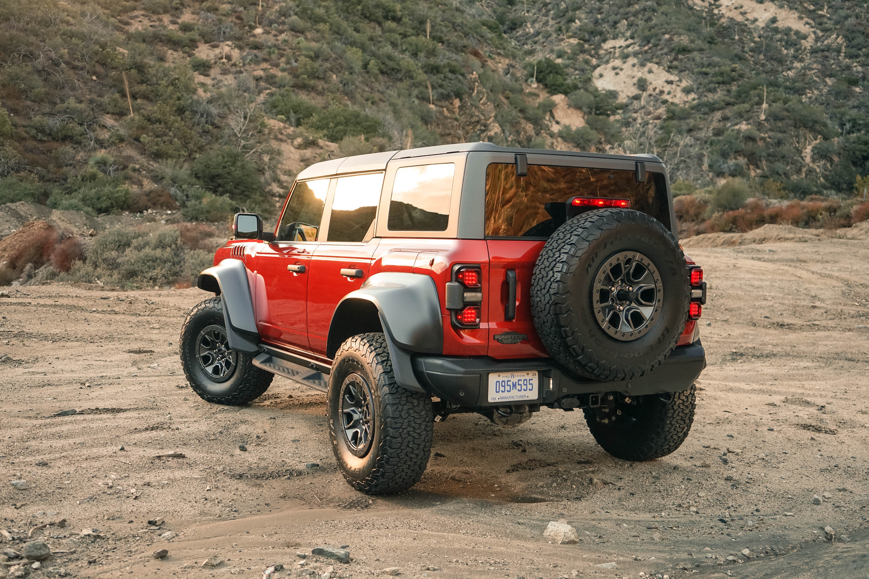 A rear-three-quarters view of the 2022 Ford Bronco Raptor in the dirt