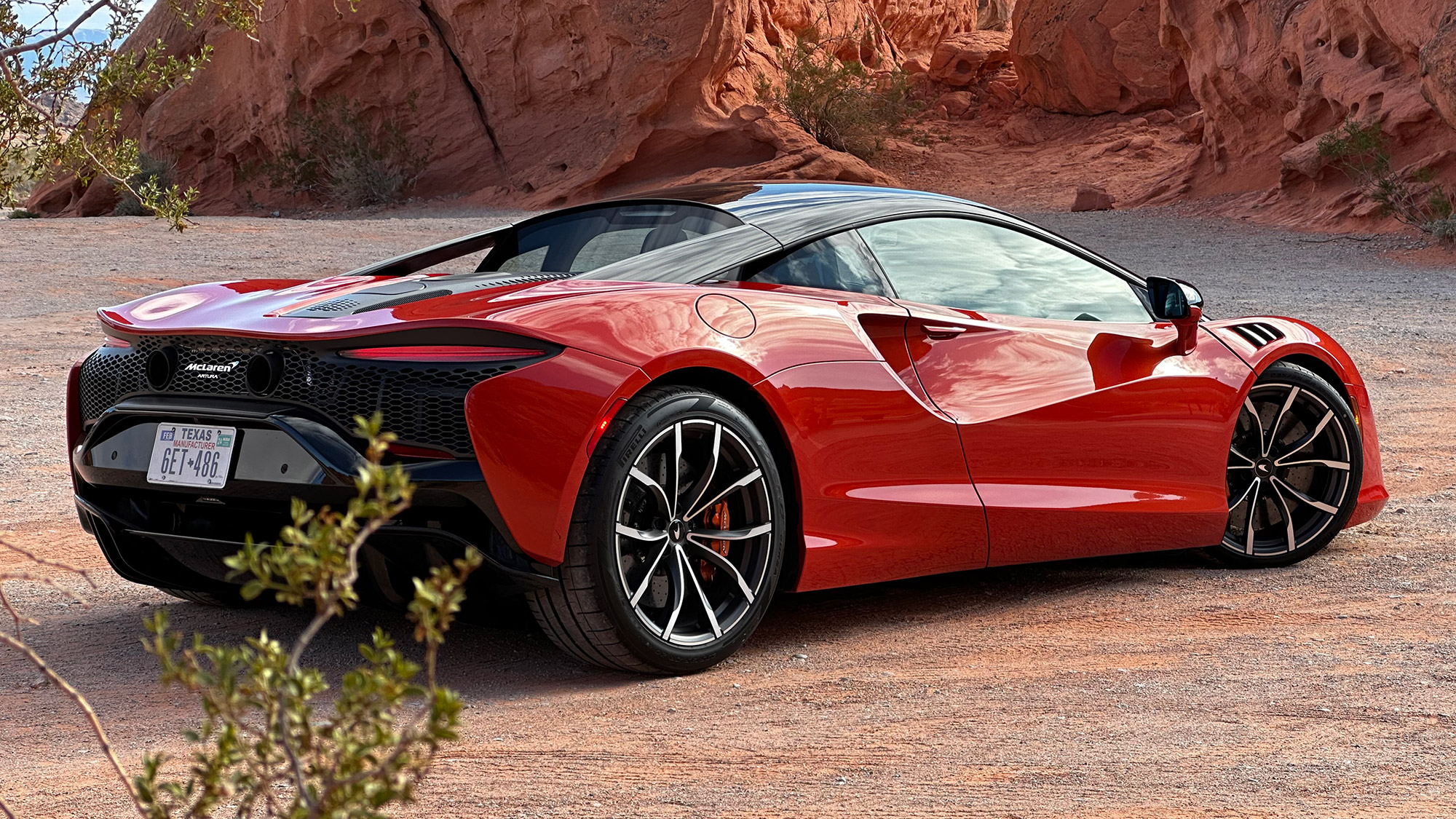 Rear quarter view of 2023 McLaren Artura, in Burnt Orange.