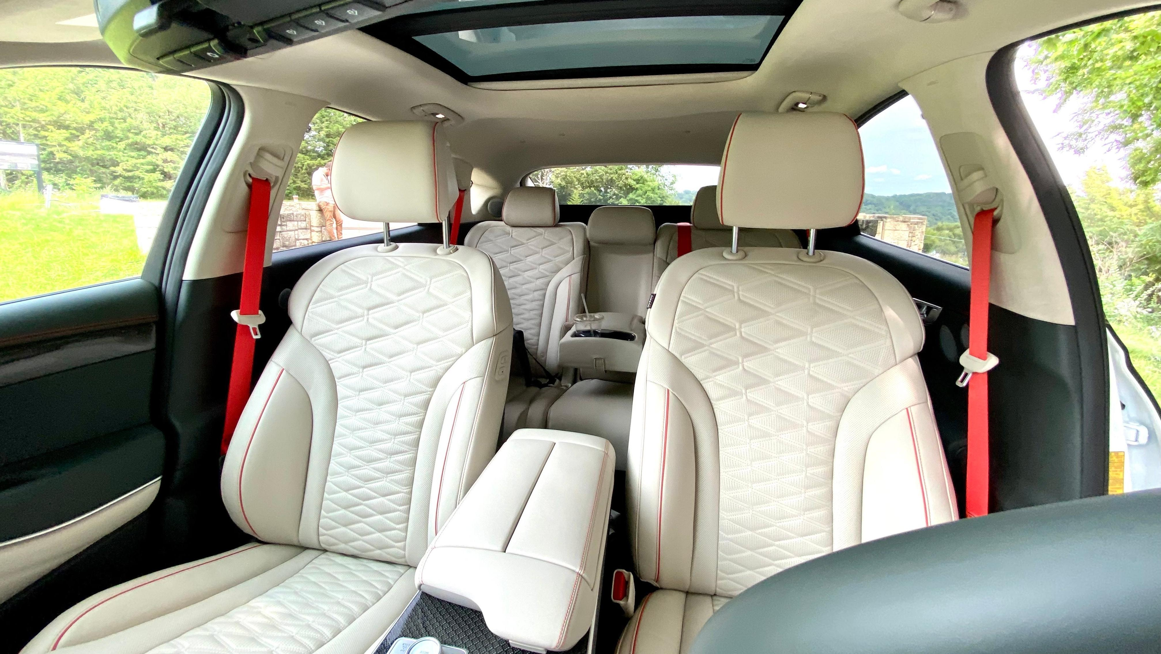 A photo looking back into the interior of the GV80 Coupe showing the gorgeous white seats and orange seatbelts