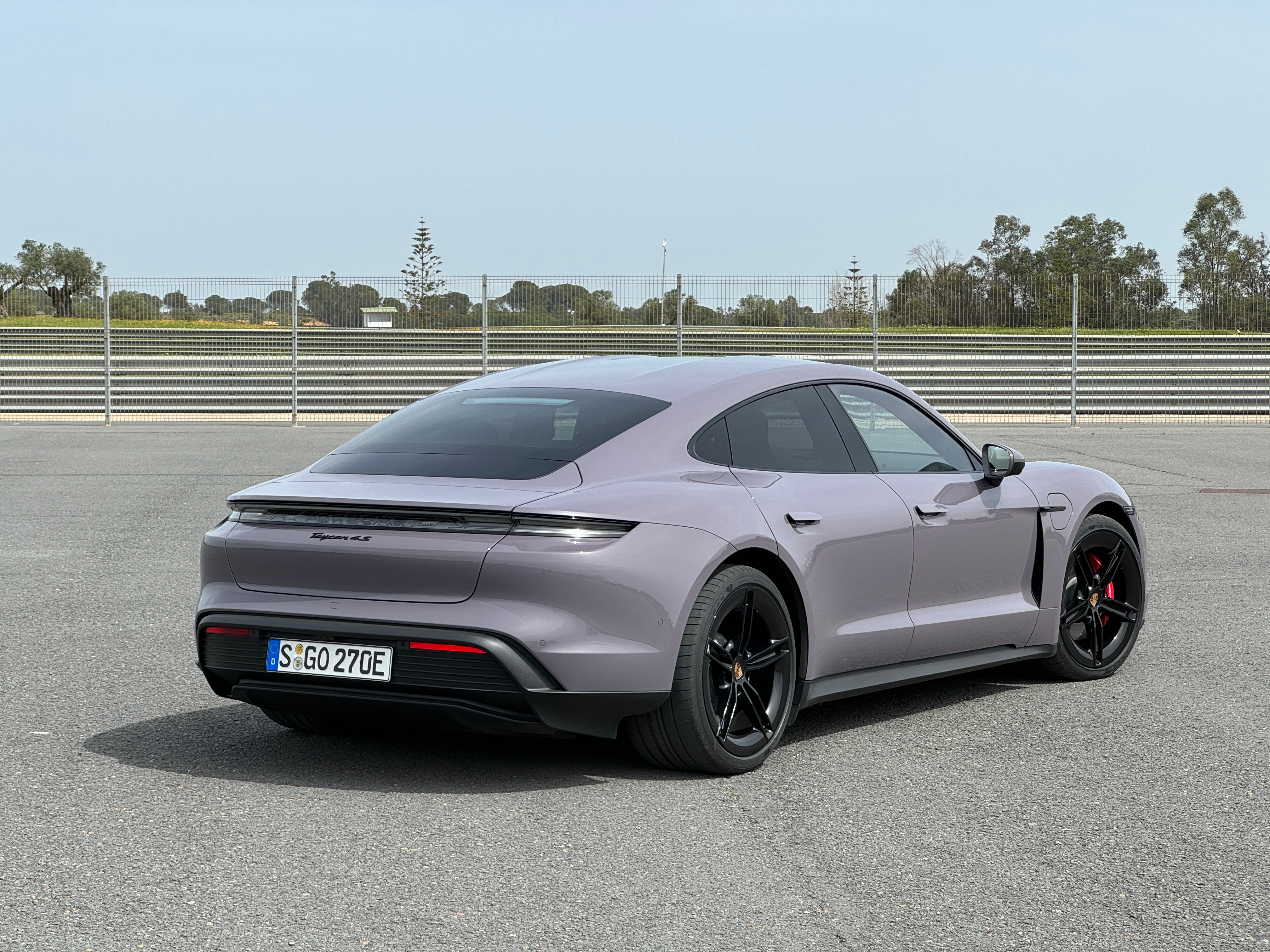 Rear 3/4 view of a lavender 2025 Porsche Taycan 4S sedan