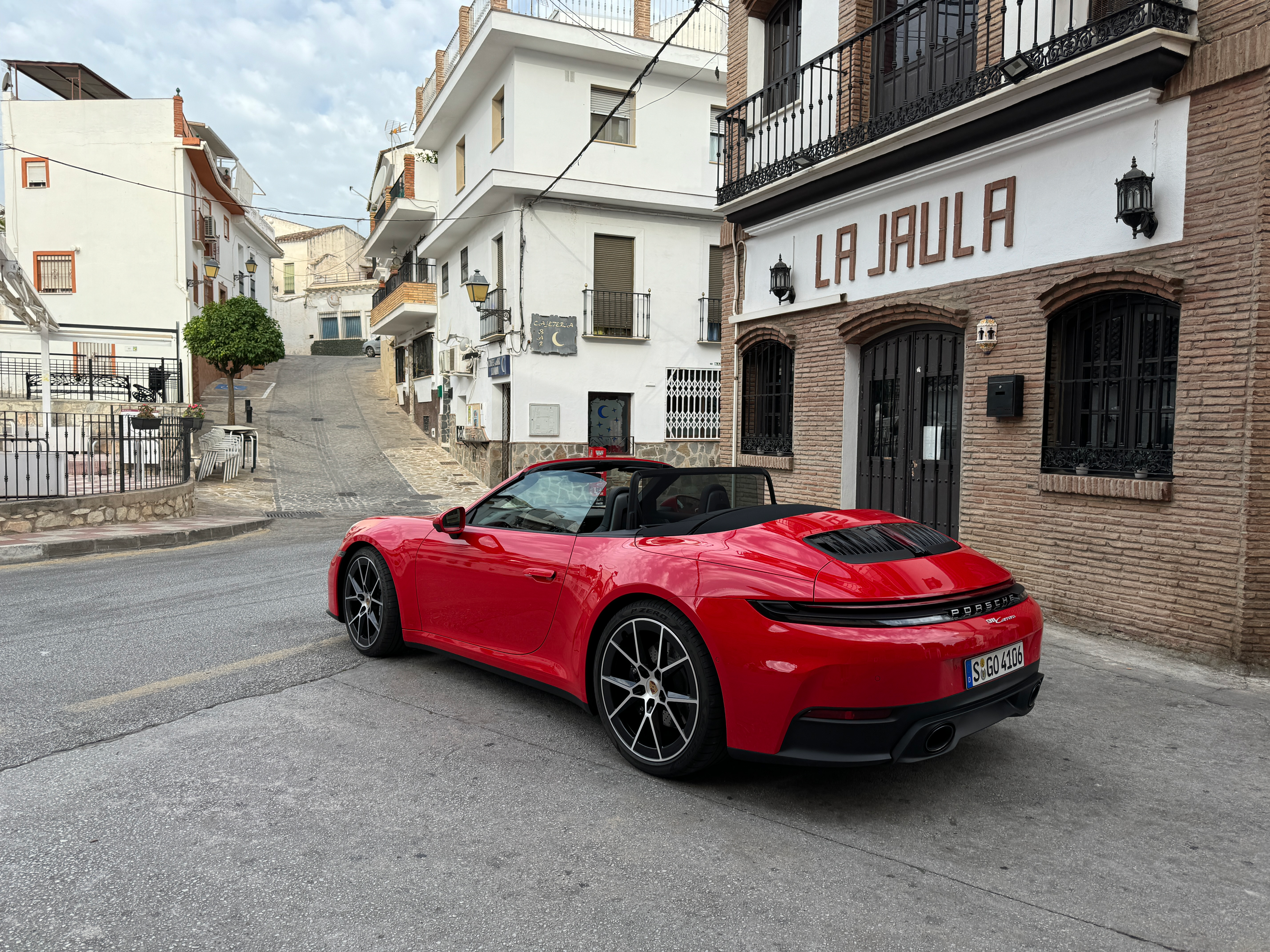 Rear 3/4 view of a red 2025 Porsche 911 Carrera Cabriolet