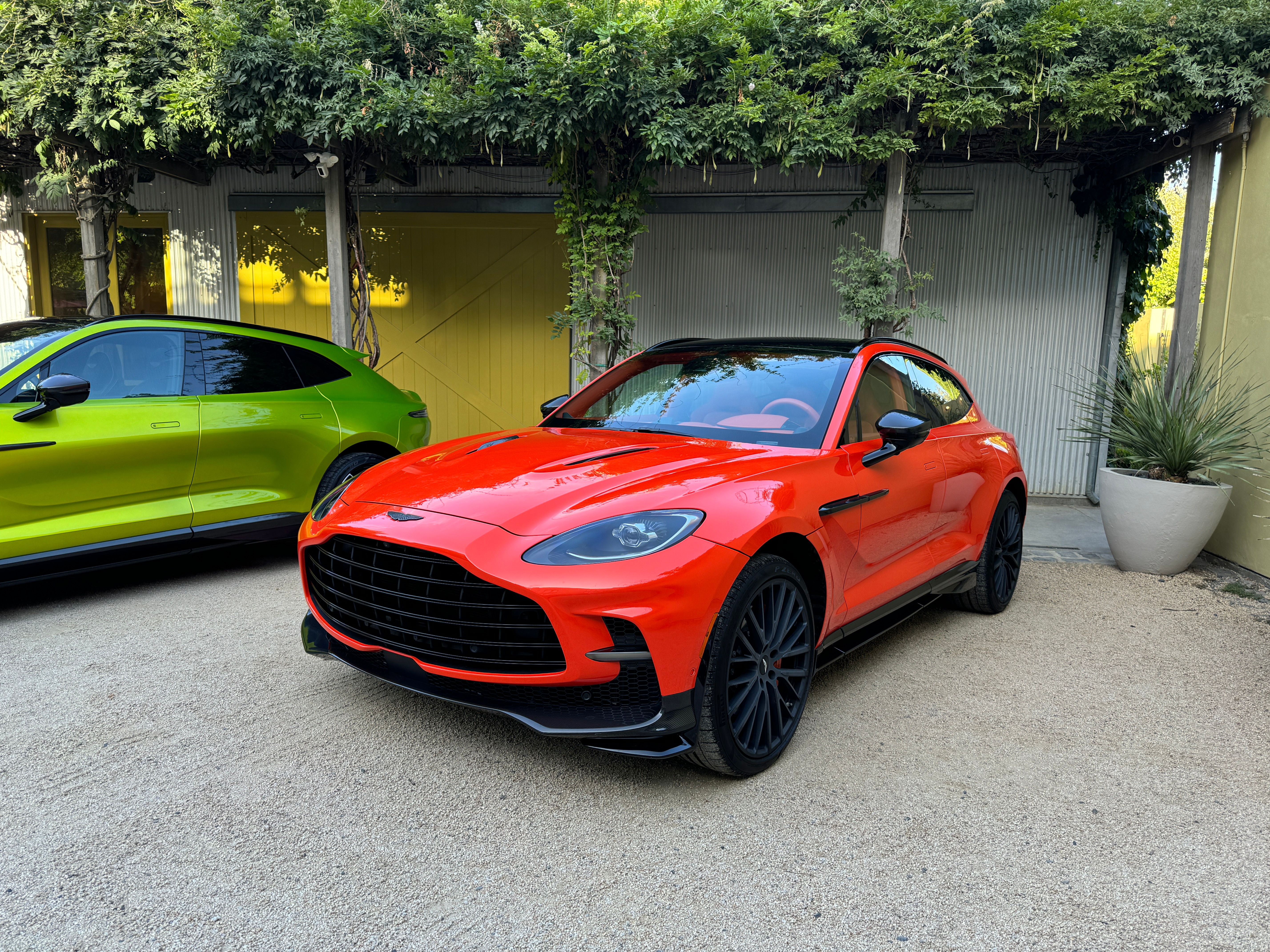 Front 3/4 view of an orange Aston Martin DBX707