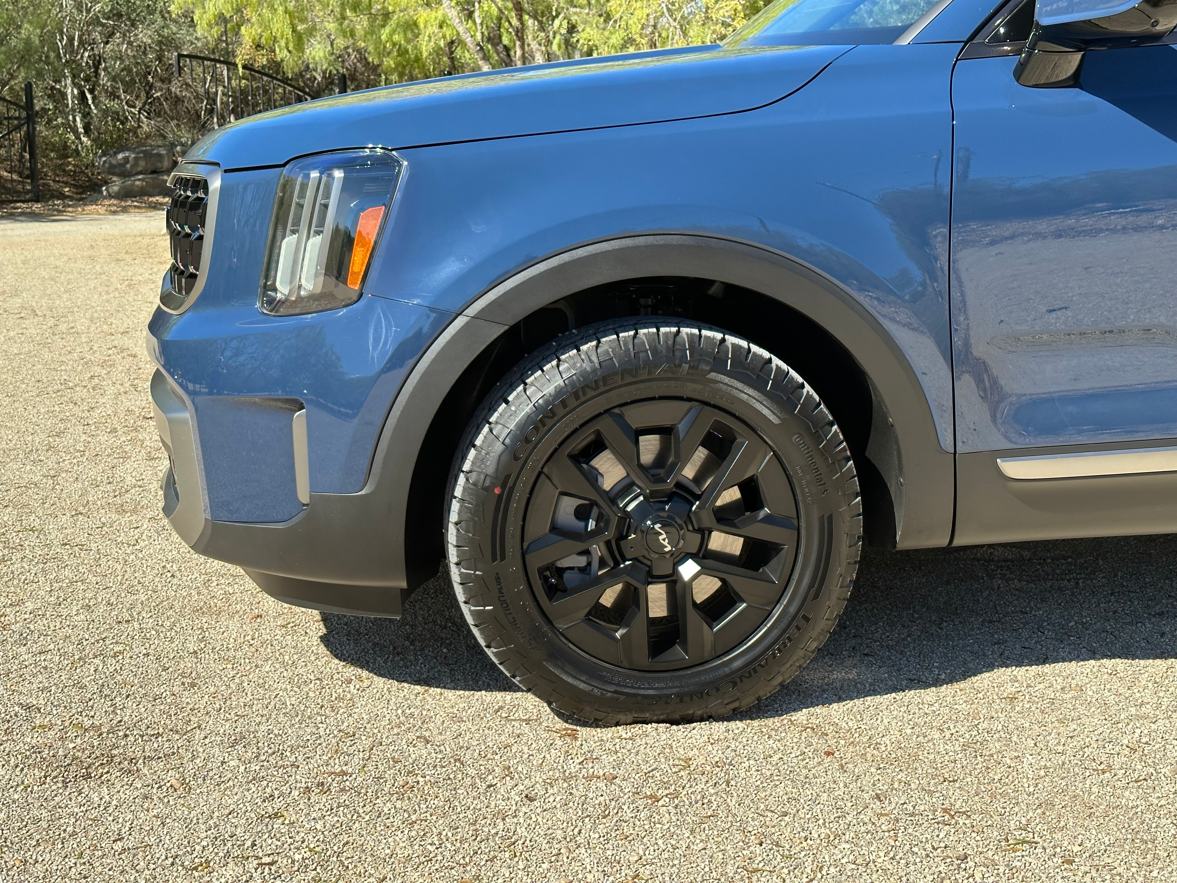 Close-up image of the left front wheel and tire on a blue 2023 Kia Telluride SX X-Pro