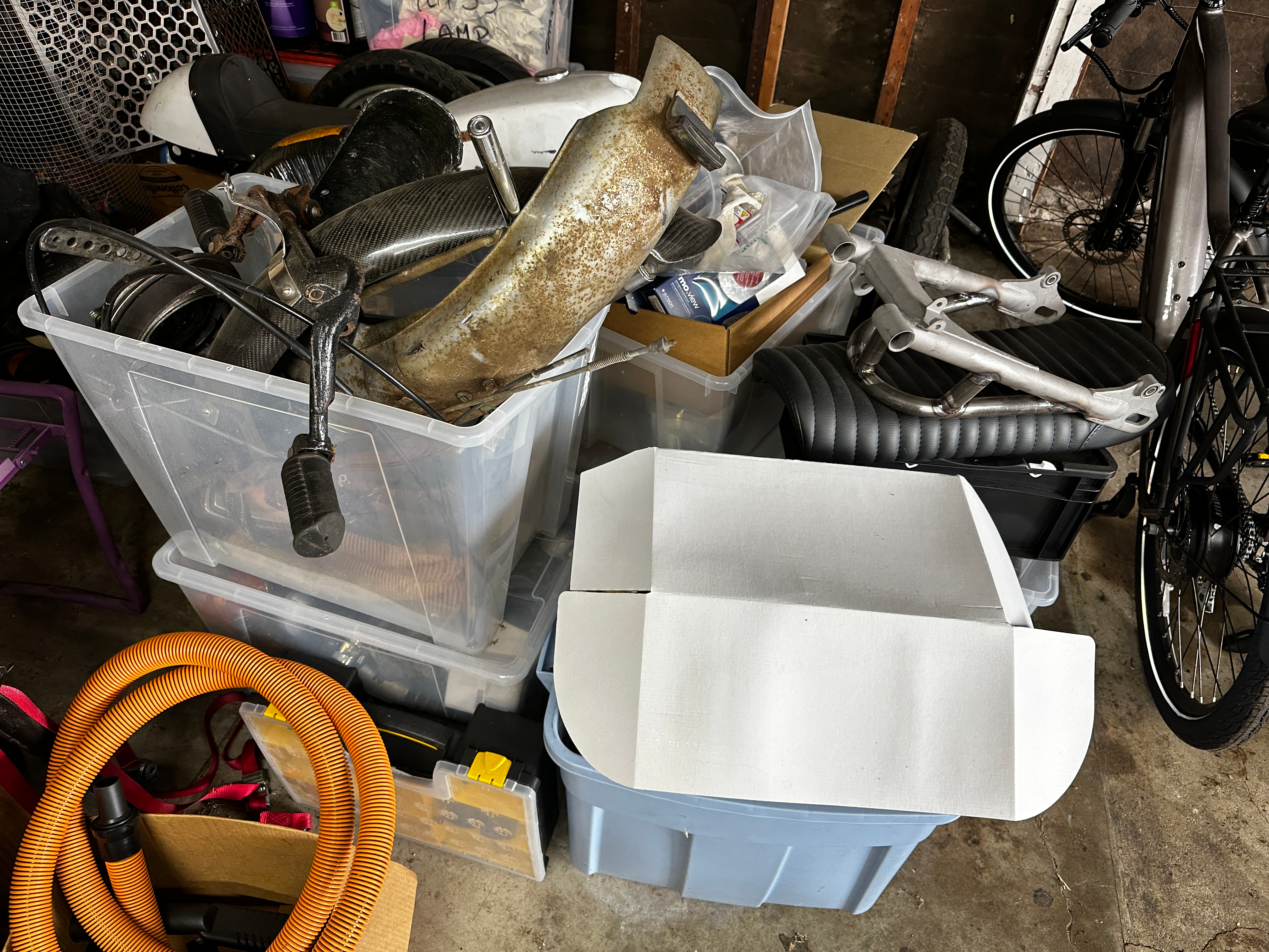 A pile of boxes filled with motorcycle parts.