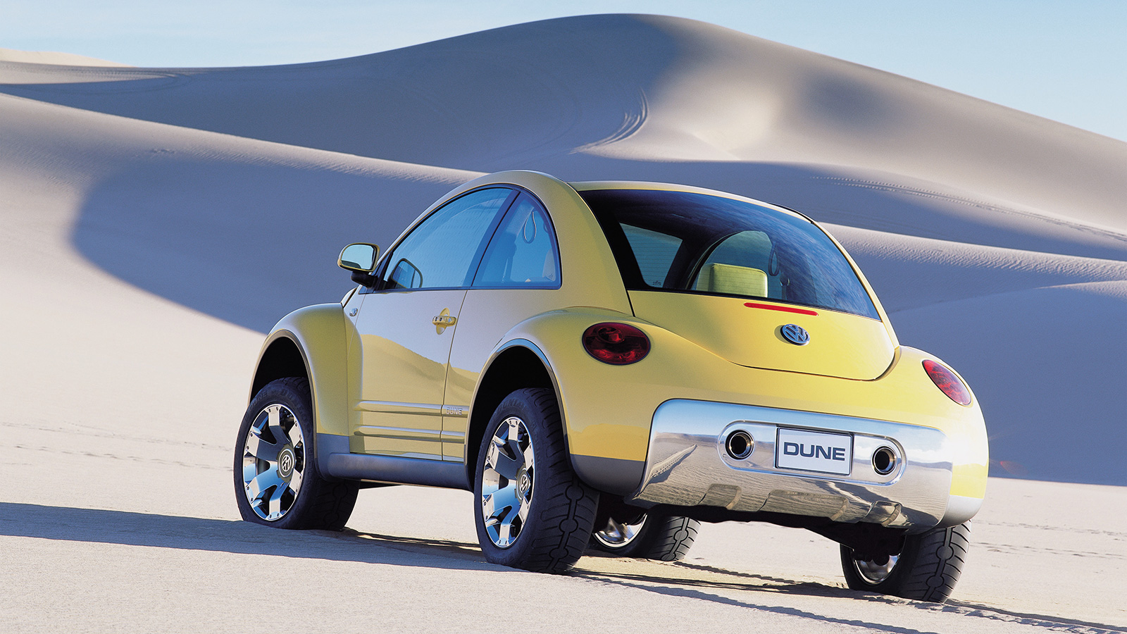 Volkswagen press image of the yellow 2000 Beetle Dune Concept, seen from a rear-quarter angle and posed in the desert.