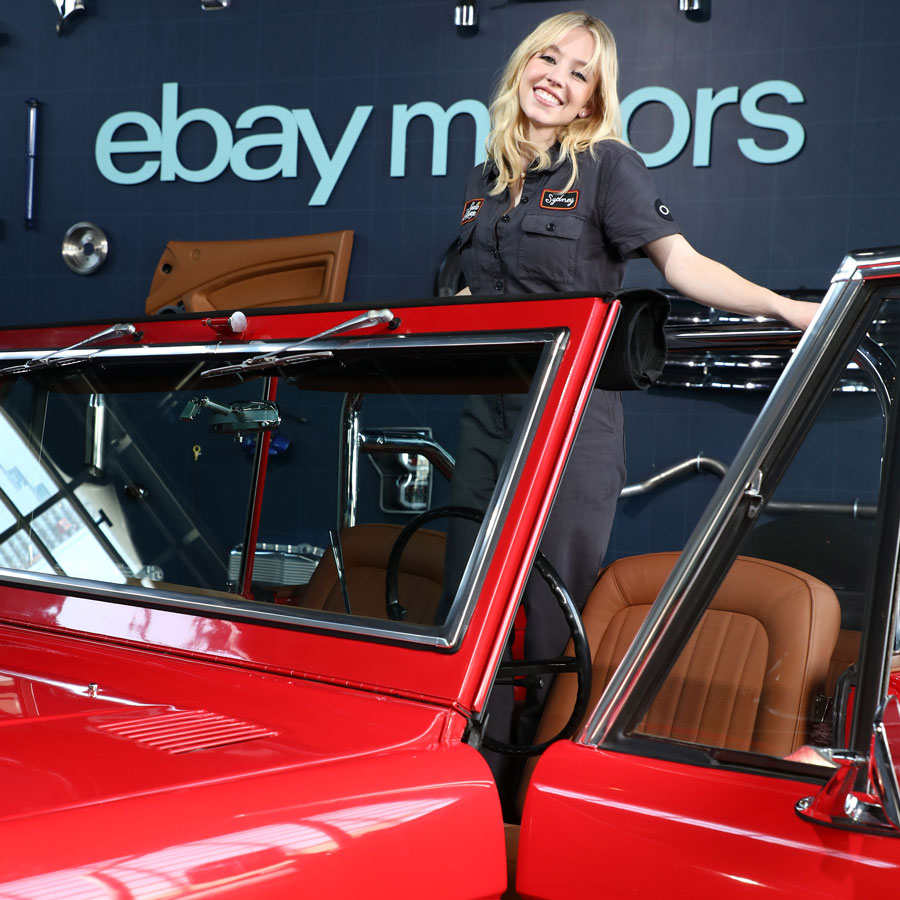 A photo of Sydney Sweeney standing in the back of her Ford Bronco. 