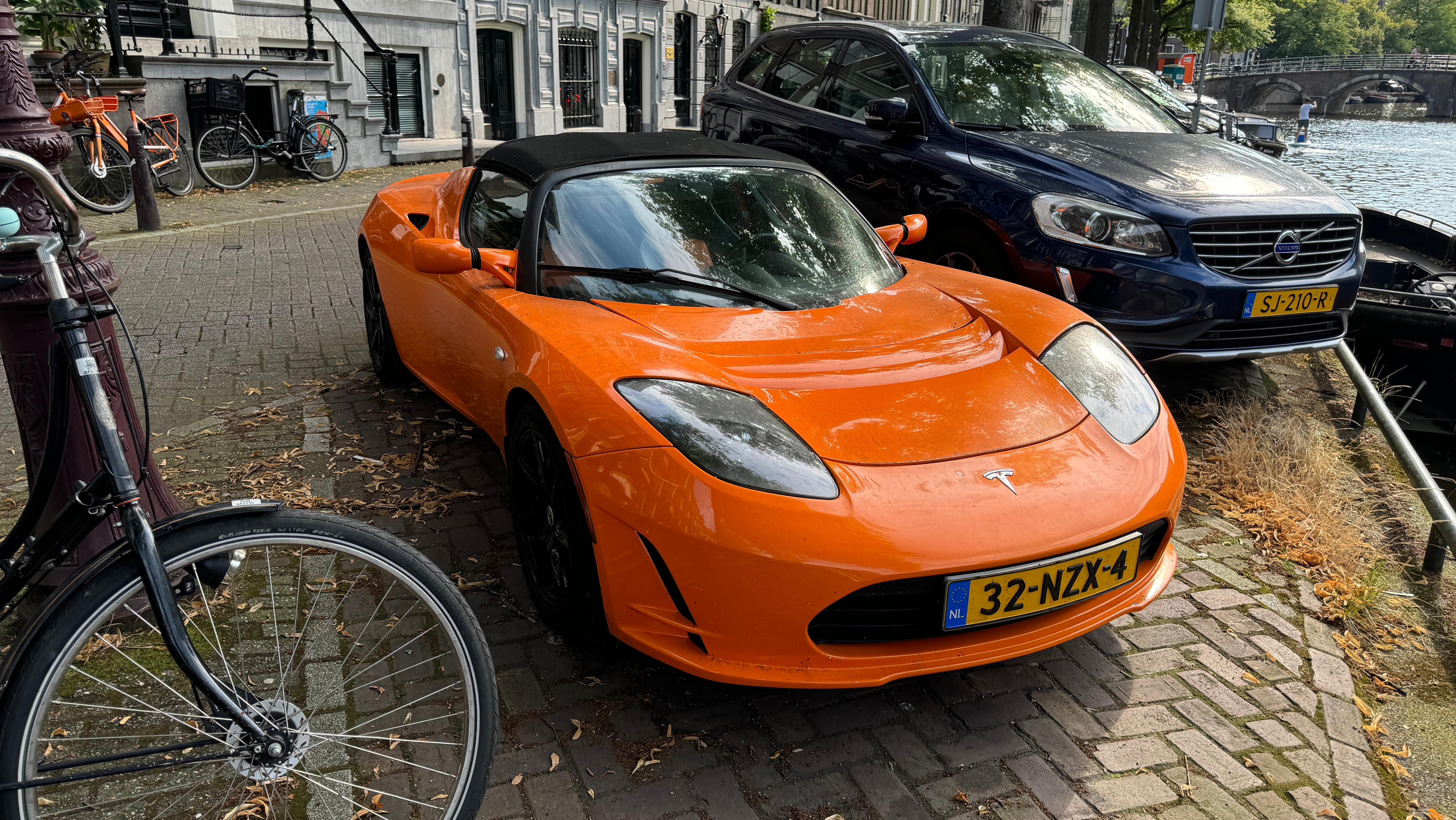 Front 3/4 view of an orange Tesla Roadster