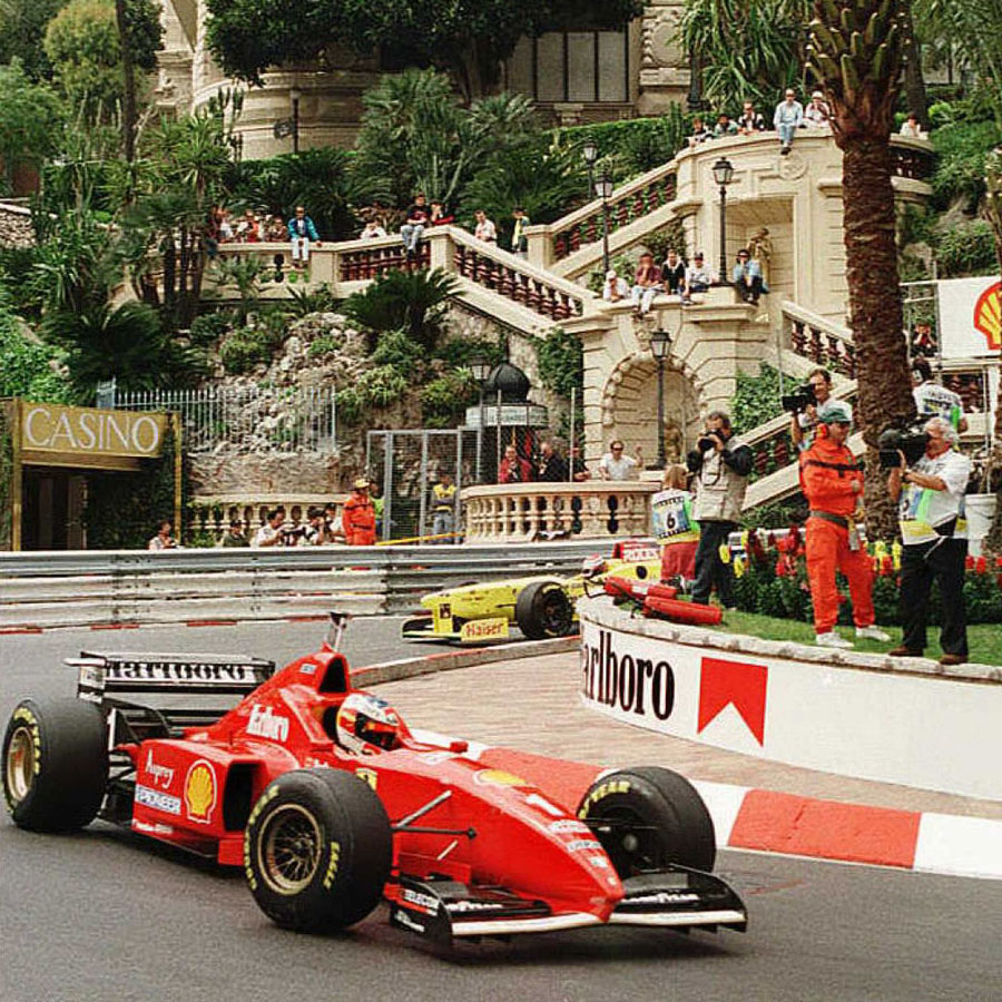 A photo of Michael Schumacher driving his red Ferrari F1 car round the streets of Monaco. 