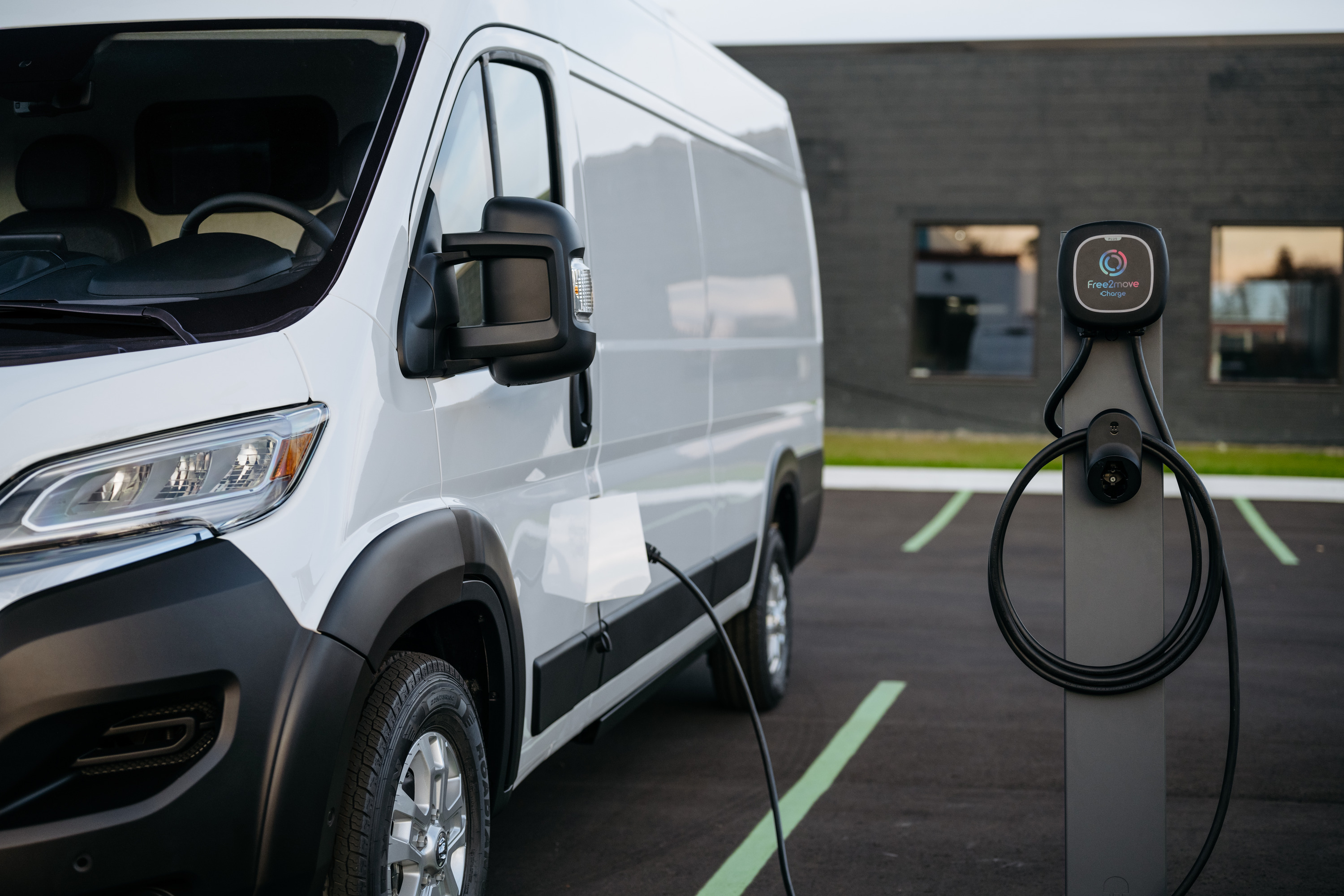 A Ram ProMaster EV van plugged into a charging station