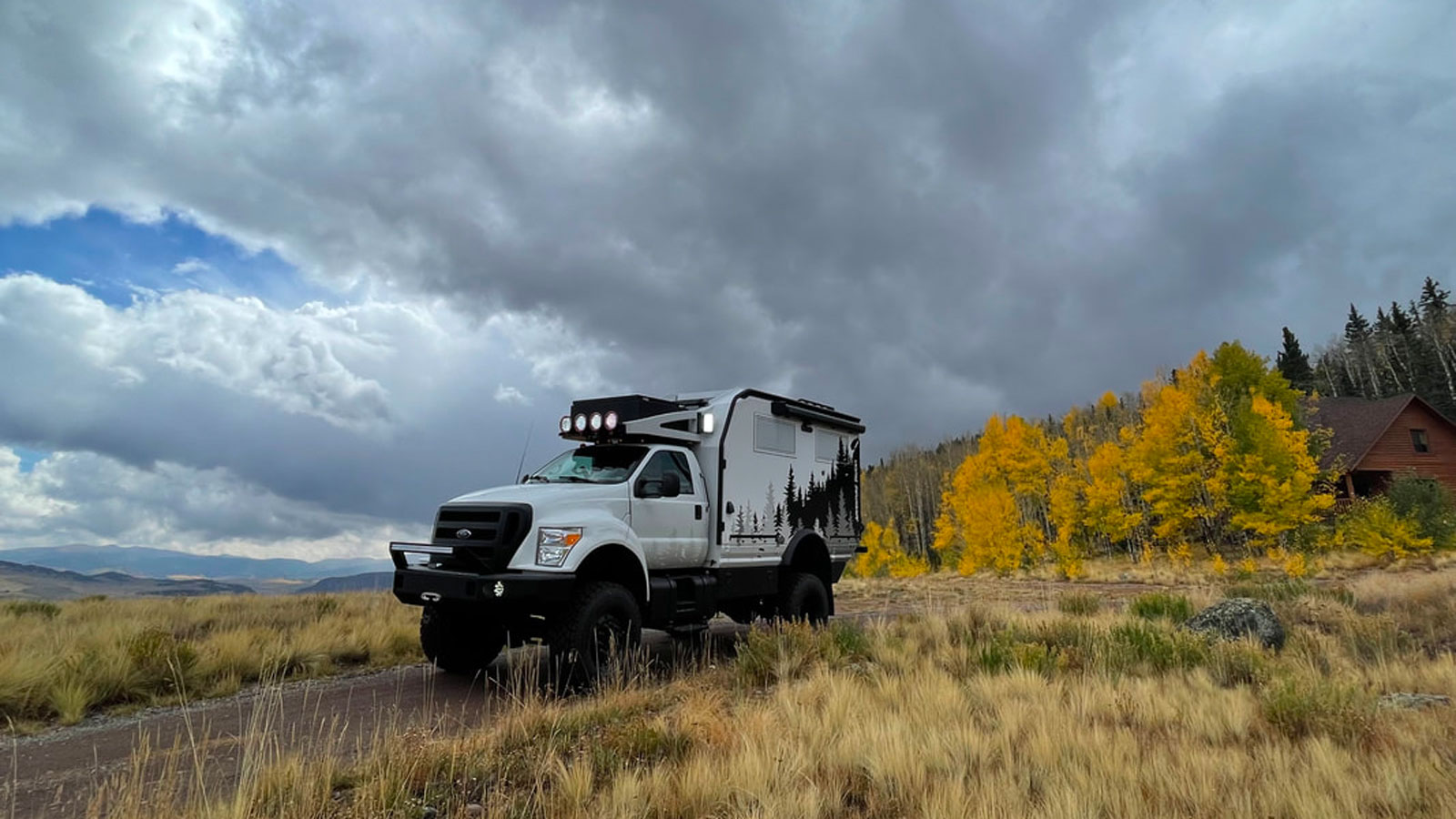 A photo of the Adventure Truck driving through a grassy field 