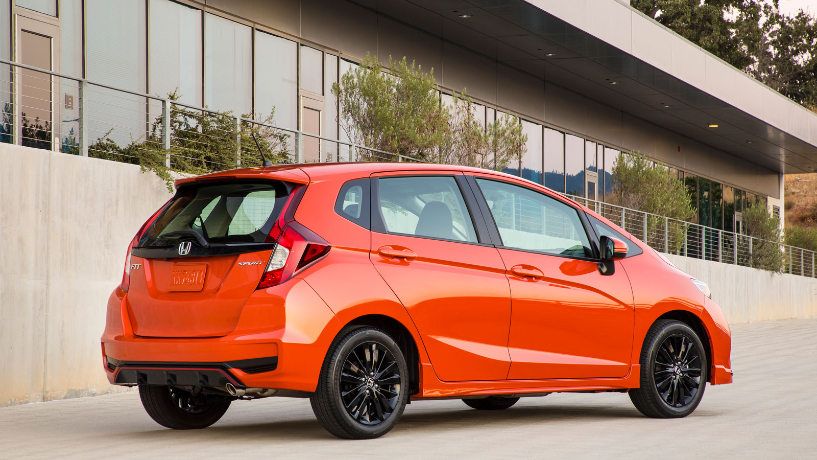 A photo of an orange Honda Fit hatchback. 