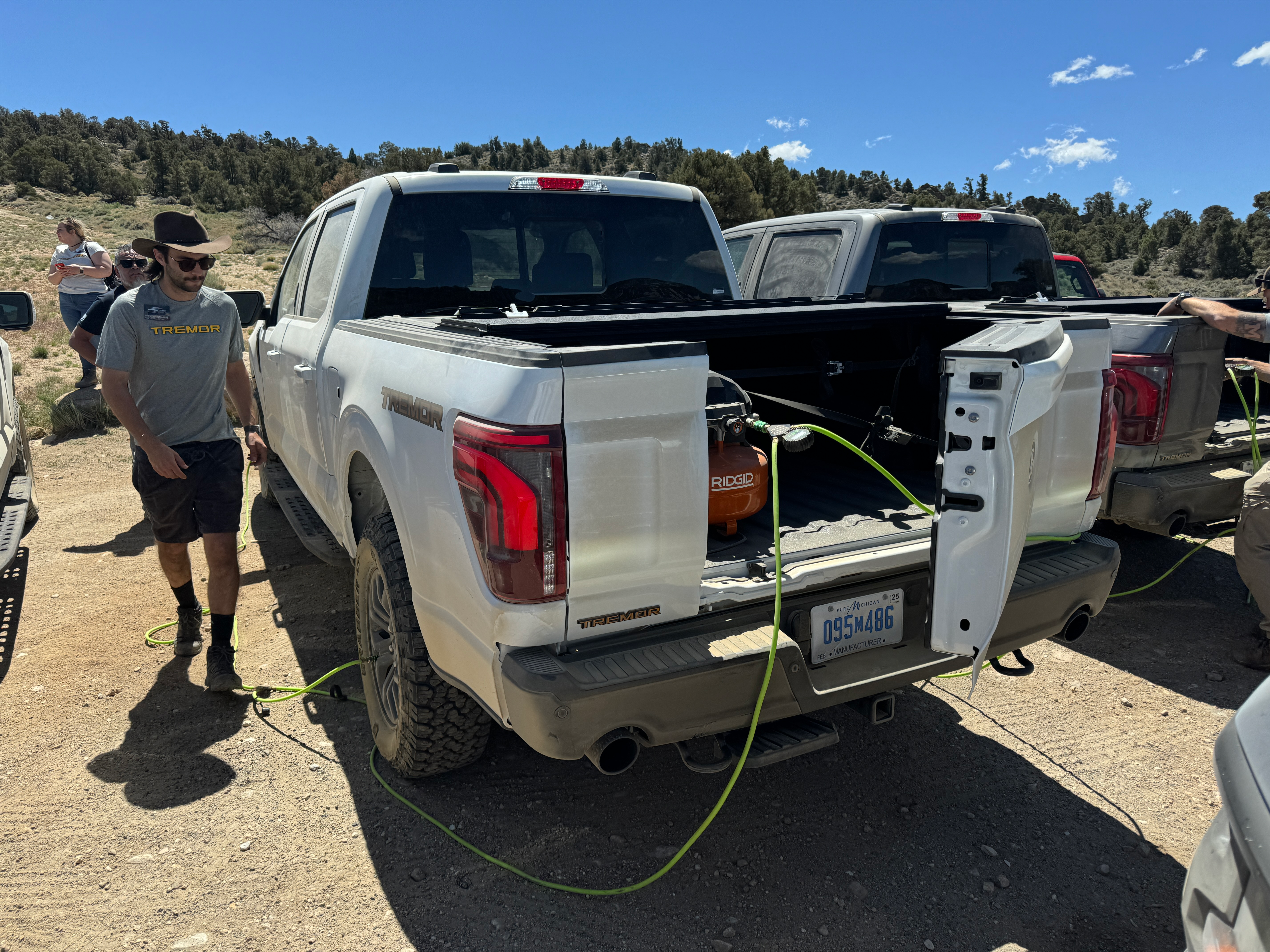 Rear view of a white 2024 Ford F-150 Tremor with the tailgate open