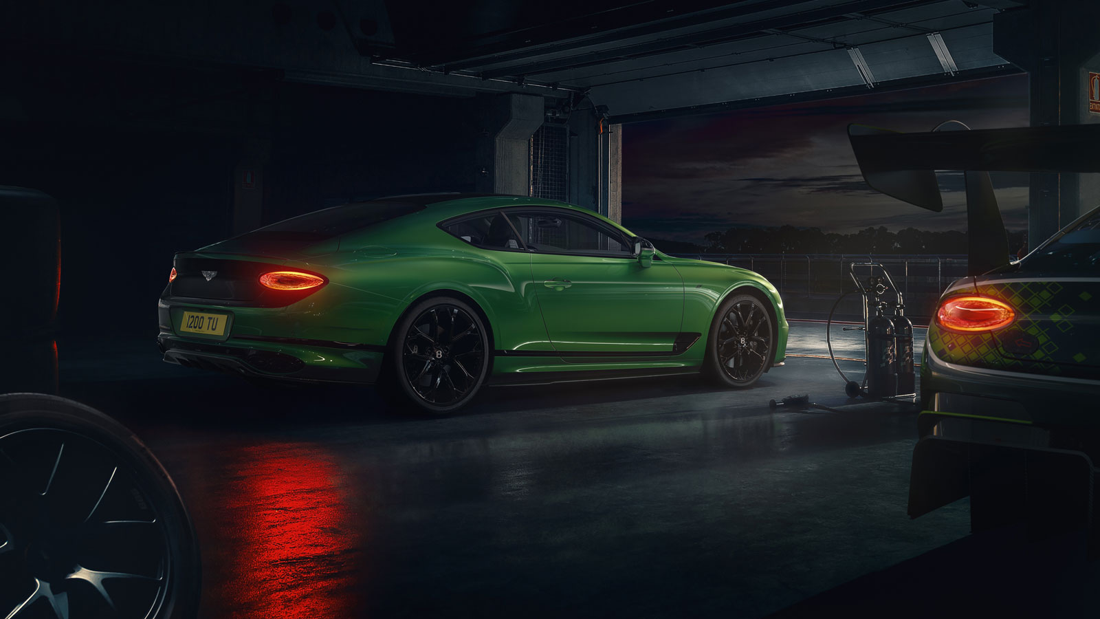 A photo of a green Bentley sports car in a garage. 