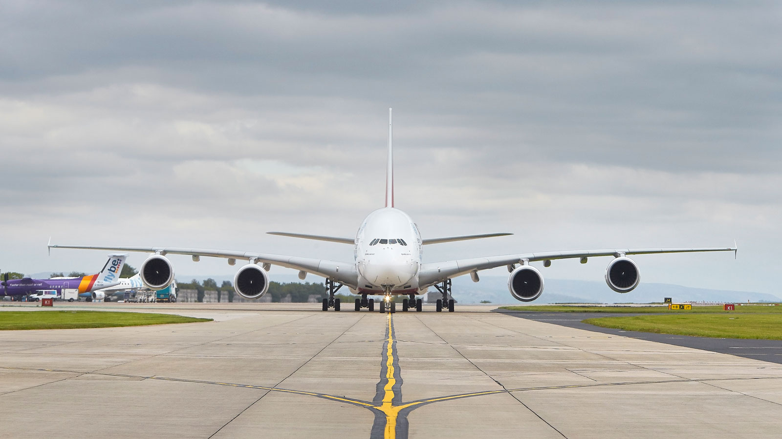 A photo of a large white plane on the tarmac at an airport. 