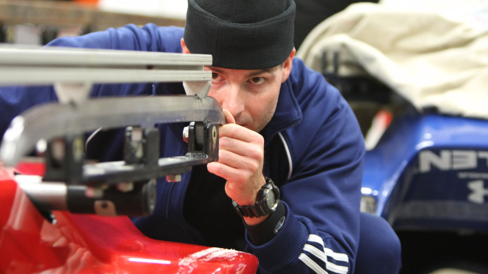 A bobsled engineer inspects one of the four runners. 