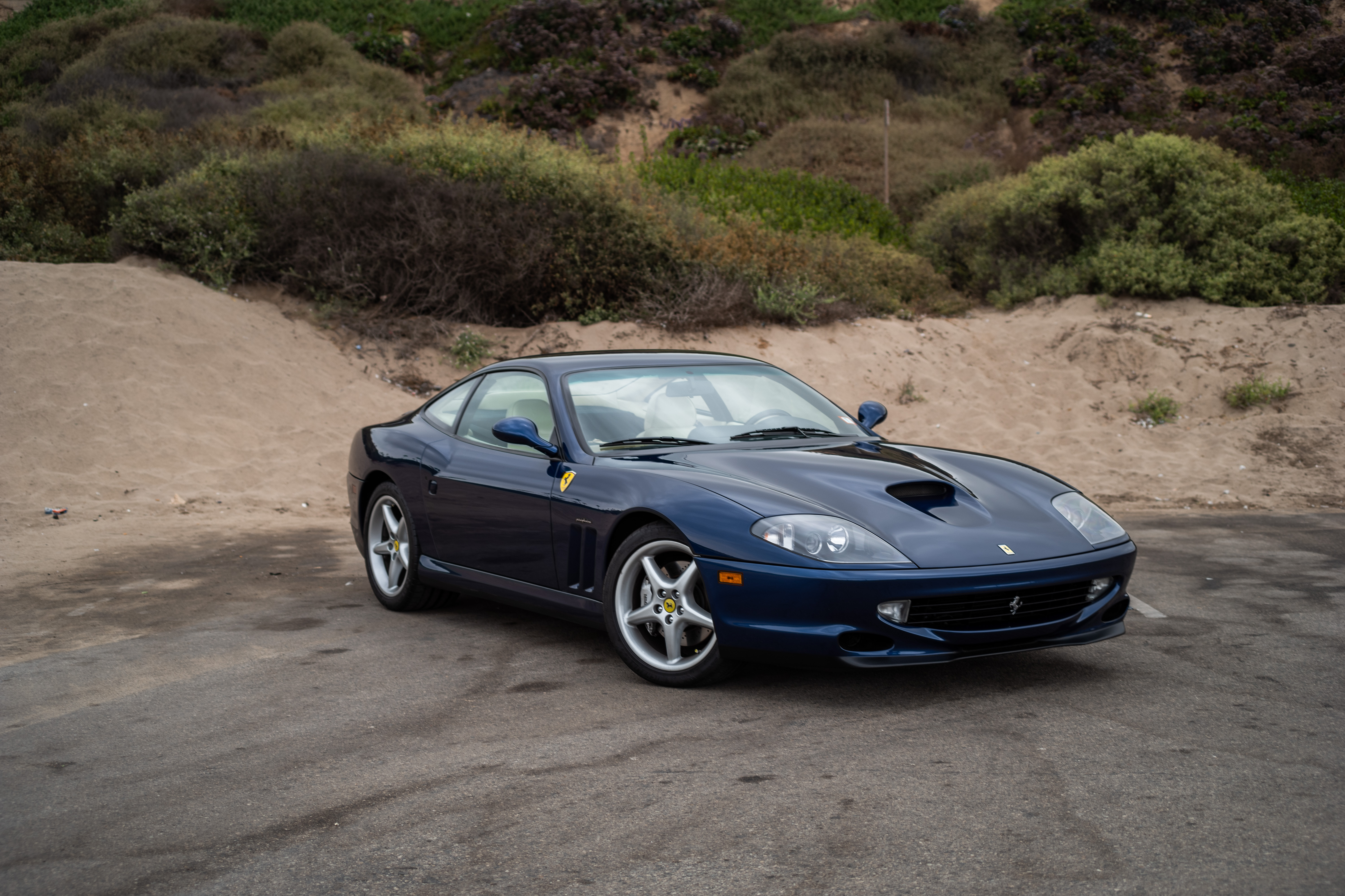 Front three-quarter view of a blue 1999 Ferrari 550 Maranello