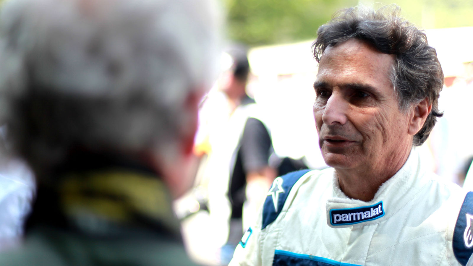 A photo of former F1 driver Nelson Piquet in white racing overalls. 