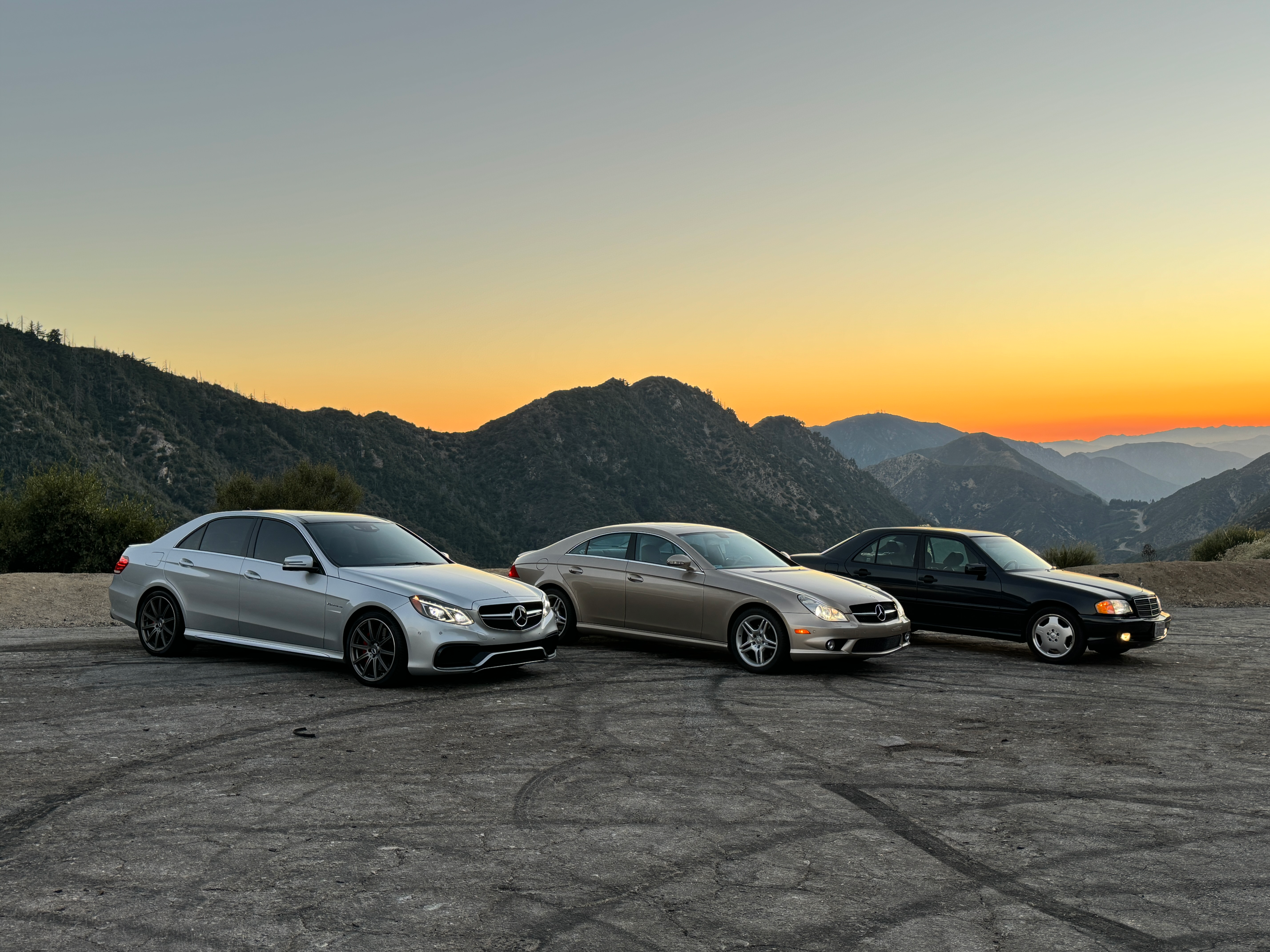 A silver Mercedes E63 AMG, gold CLS500 and blue C43 parked together